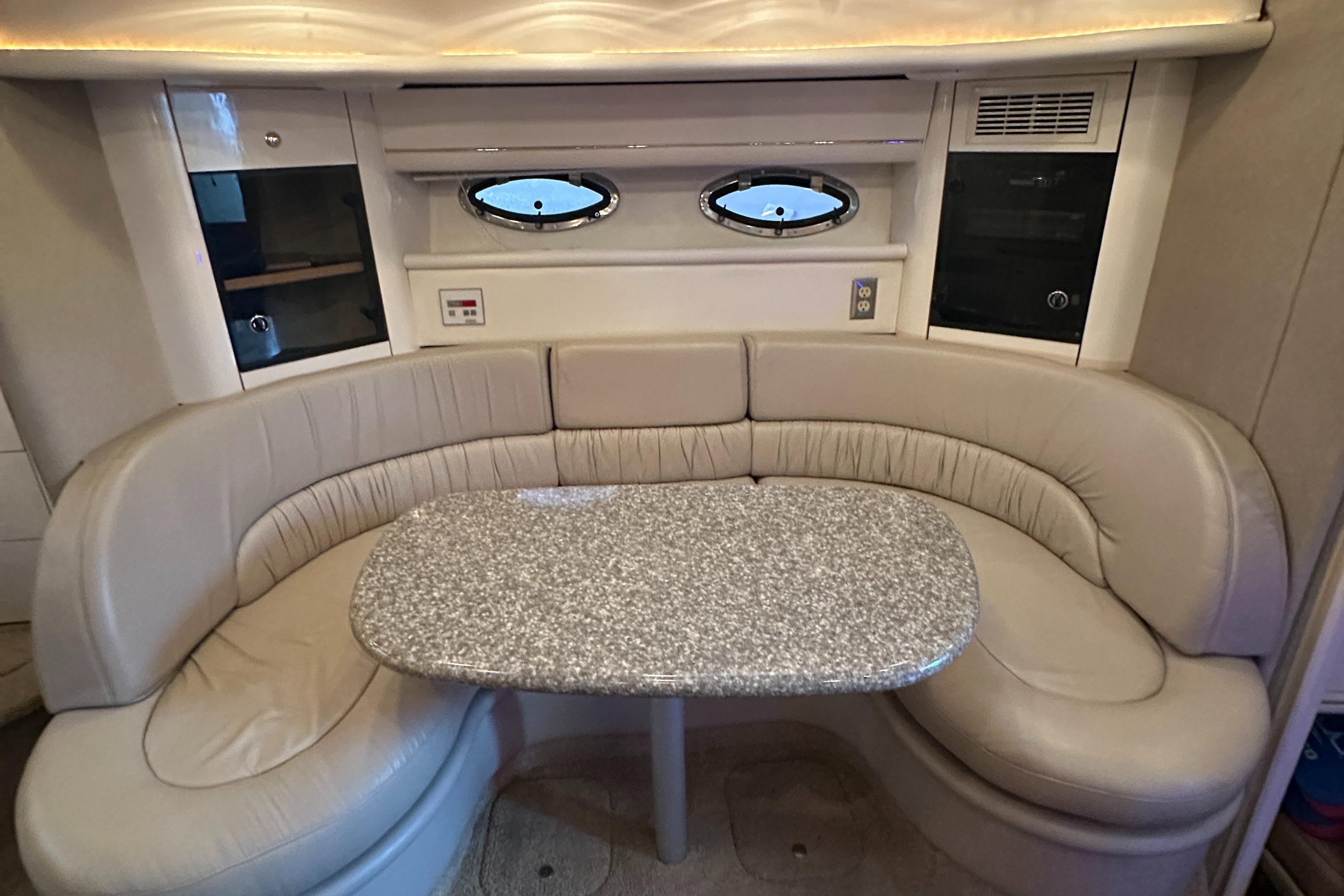 1998 Maxum 3700 SCR yacht interior with curved seating and oval windows.