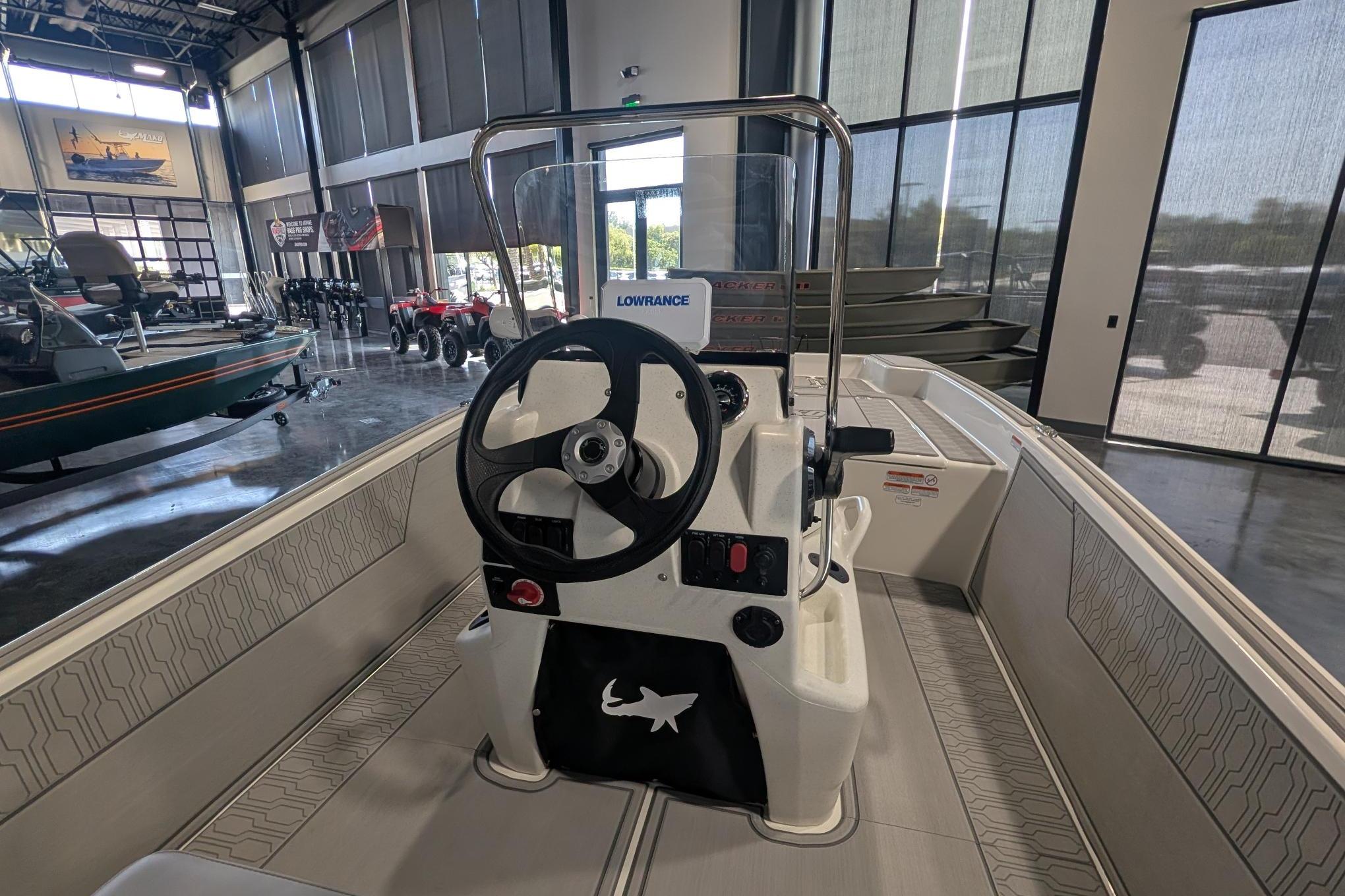 2026 Mako Pro Skiff 17 CC boat interior with steering wheel in showroom.