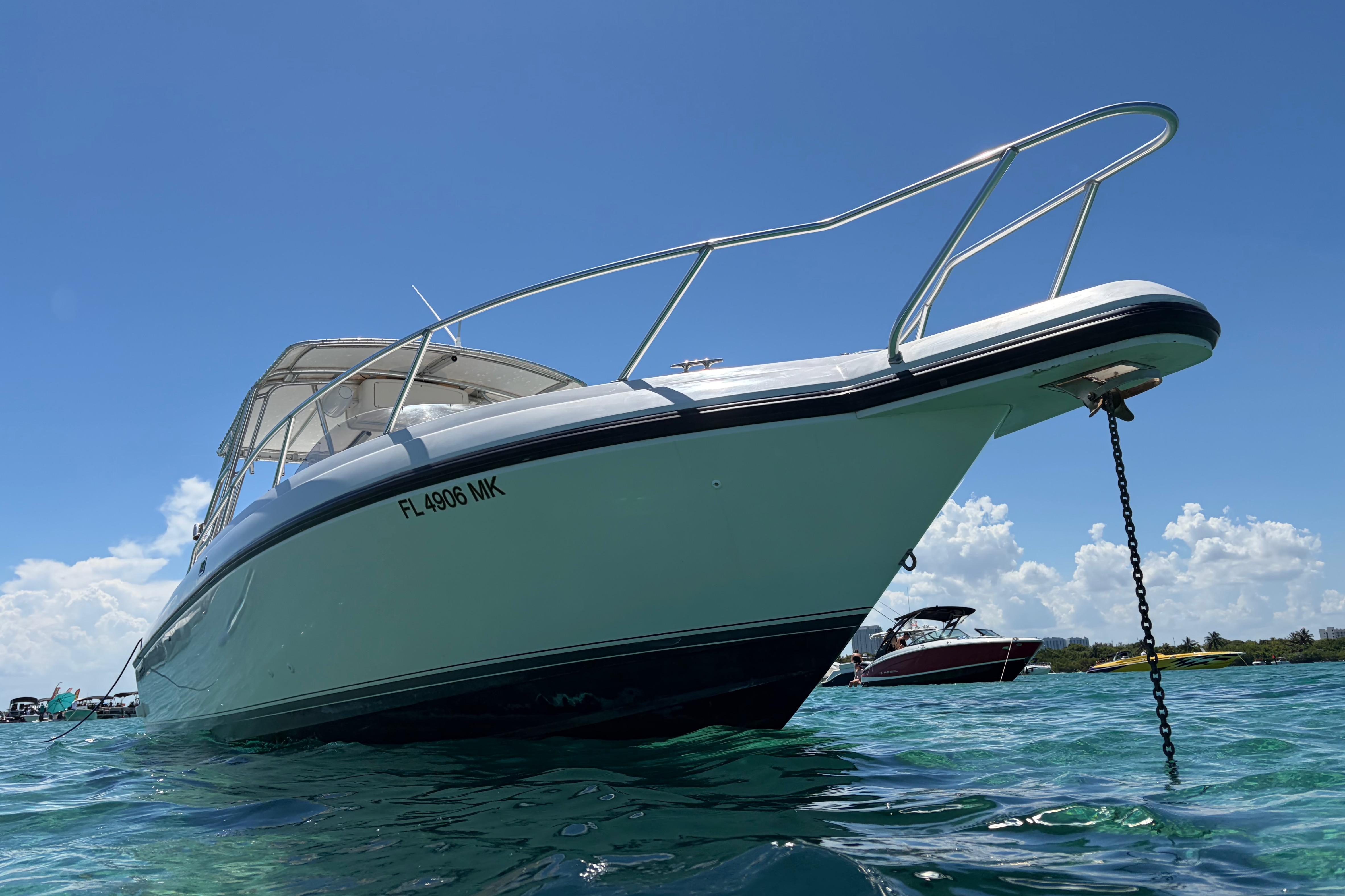 1998 Intrepid 339 Walkaround boat anchored in clear blue water under a sunny sky.