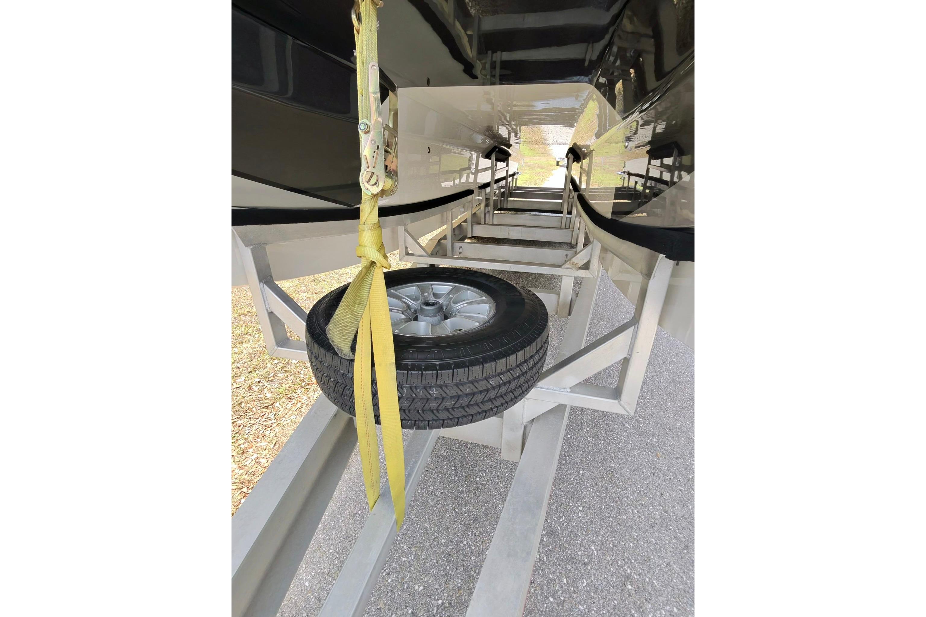 Underneath view of a 2025 Nor-Tech 4000 Roadster on a trailer with a spare tire.