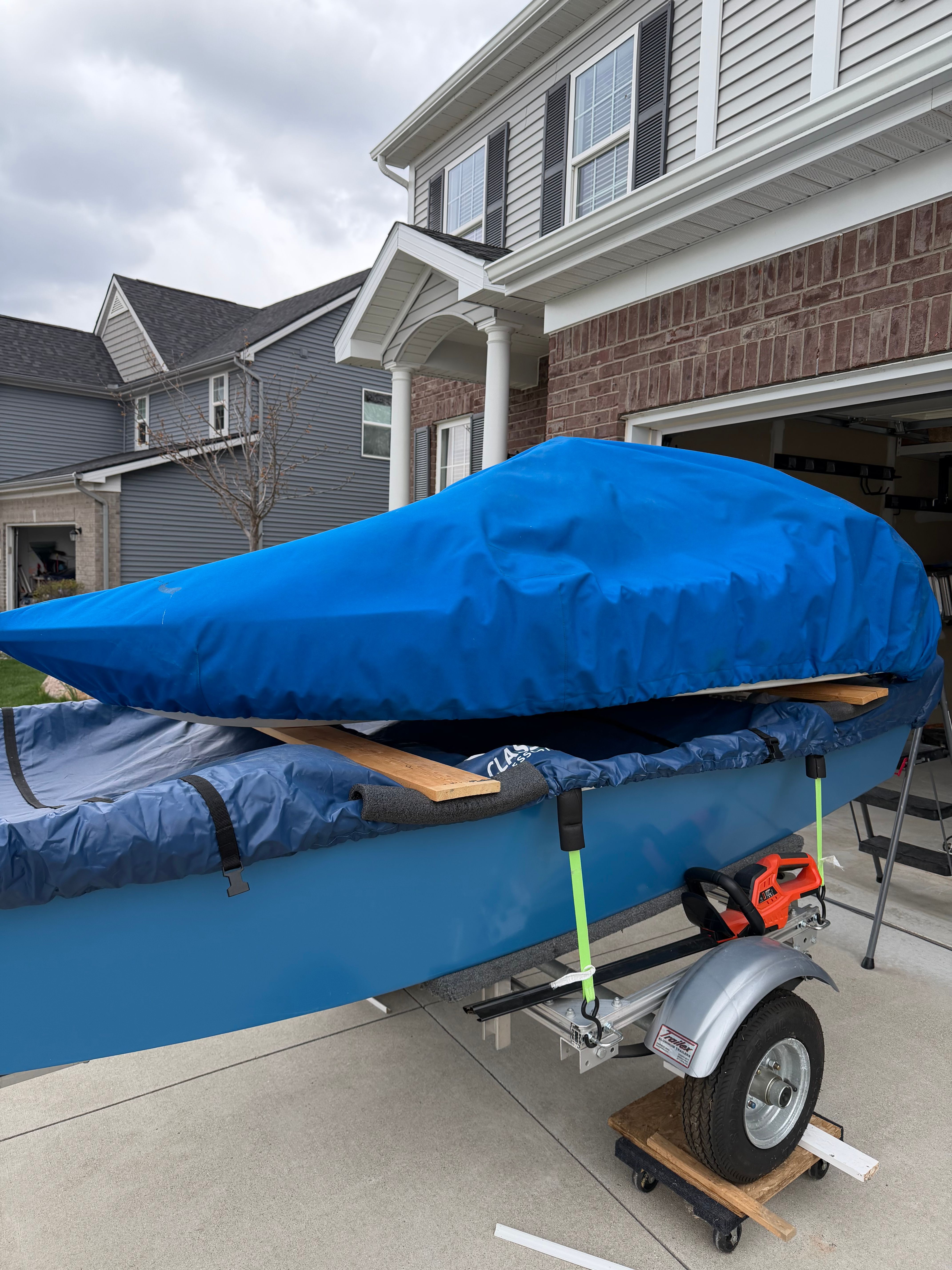 A 2013 Cocktail Class Racer on a trailer, covered with a blue tarp.