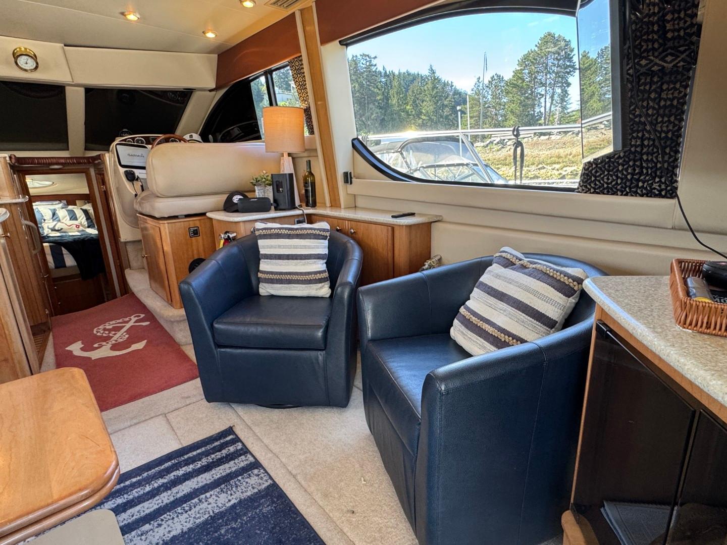 Interior of 2003 Meridian 381 Sedan yacht with blue chairs and striped cushions.
