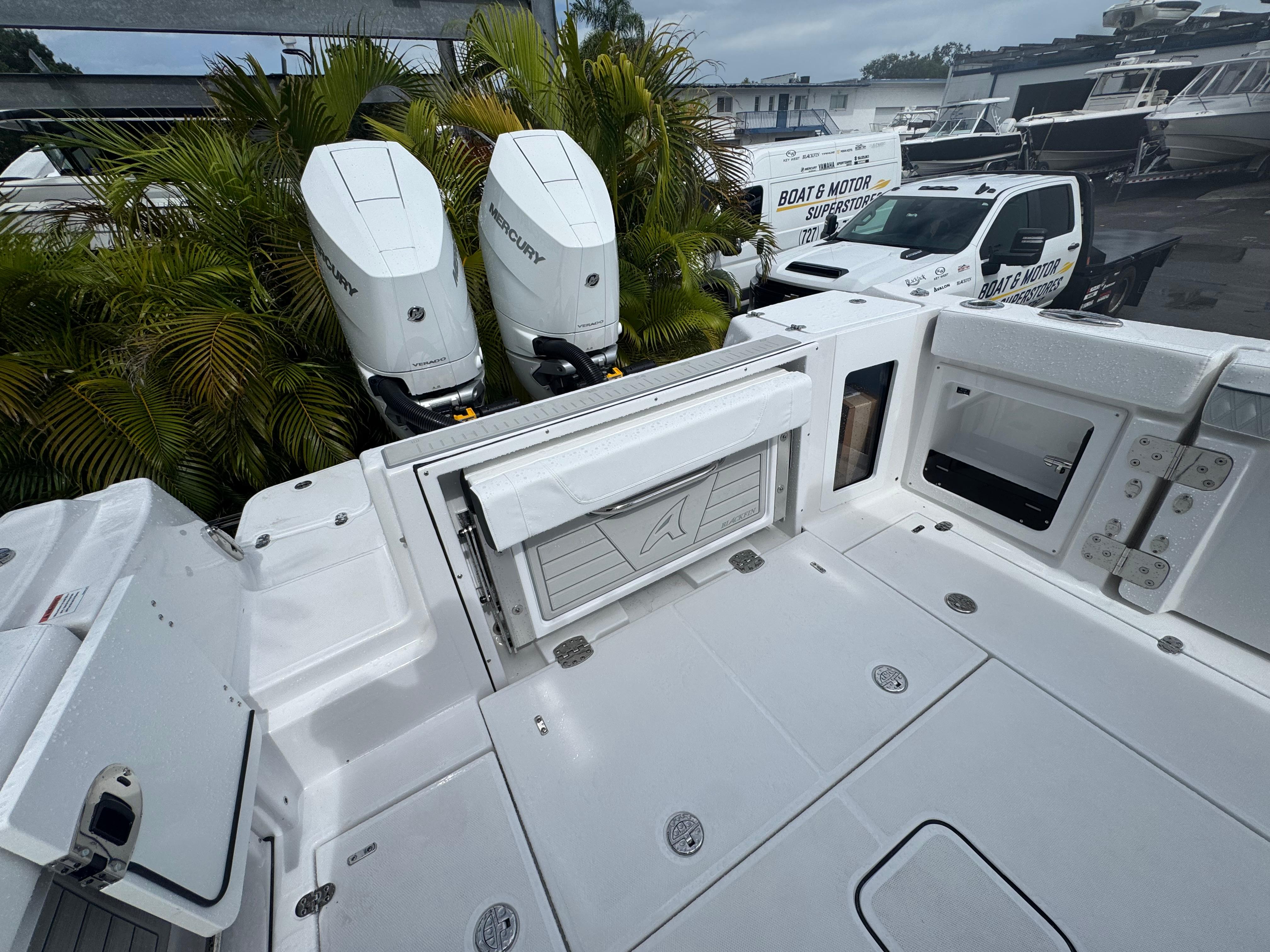 2026 Blackfin 302 CC boat with dual Mercury outboard engines, docked near palm trees.