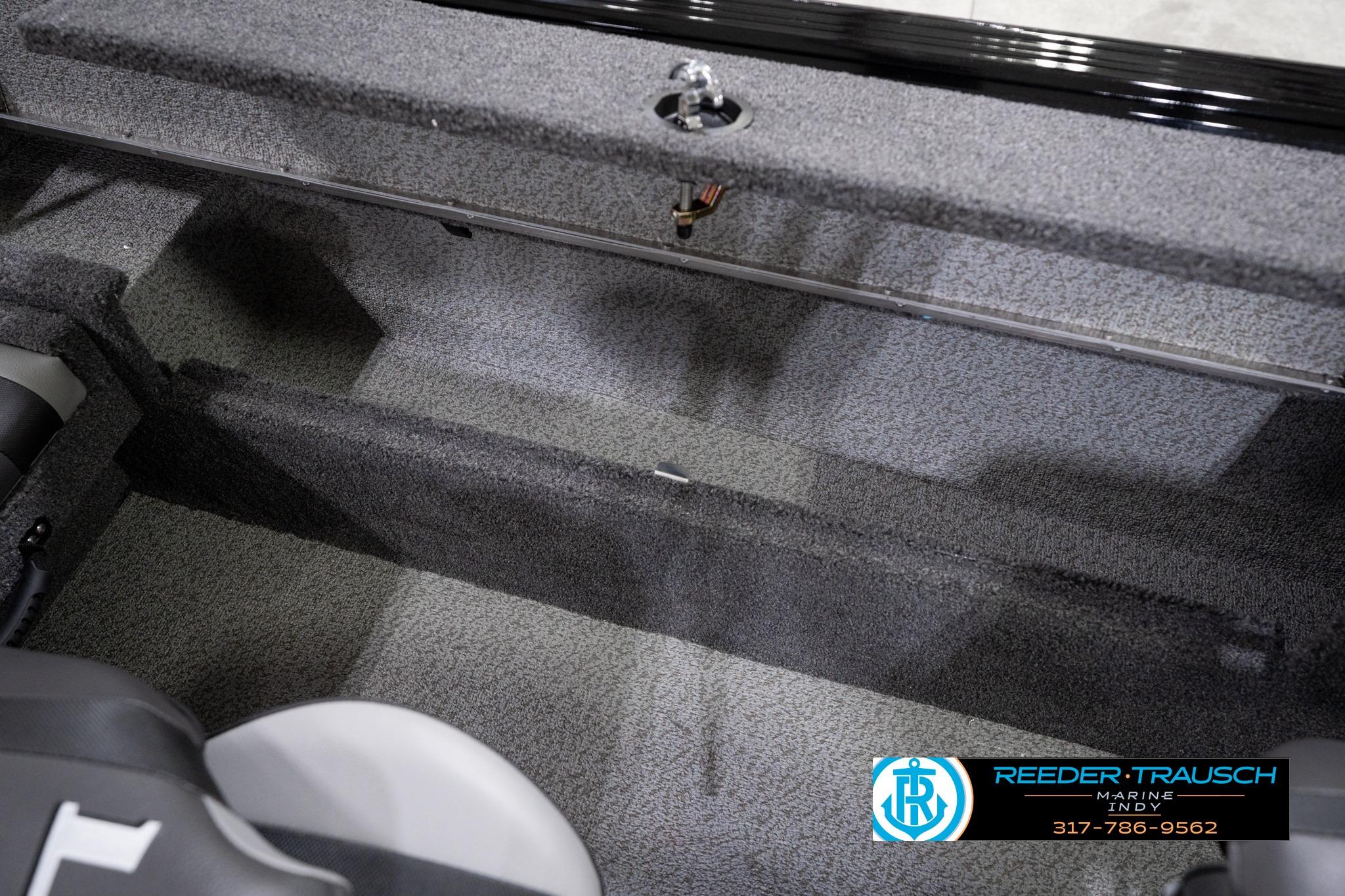 2026 Lund 1775 Impact XS SS boat interior with gray carpet and storage compartments.