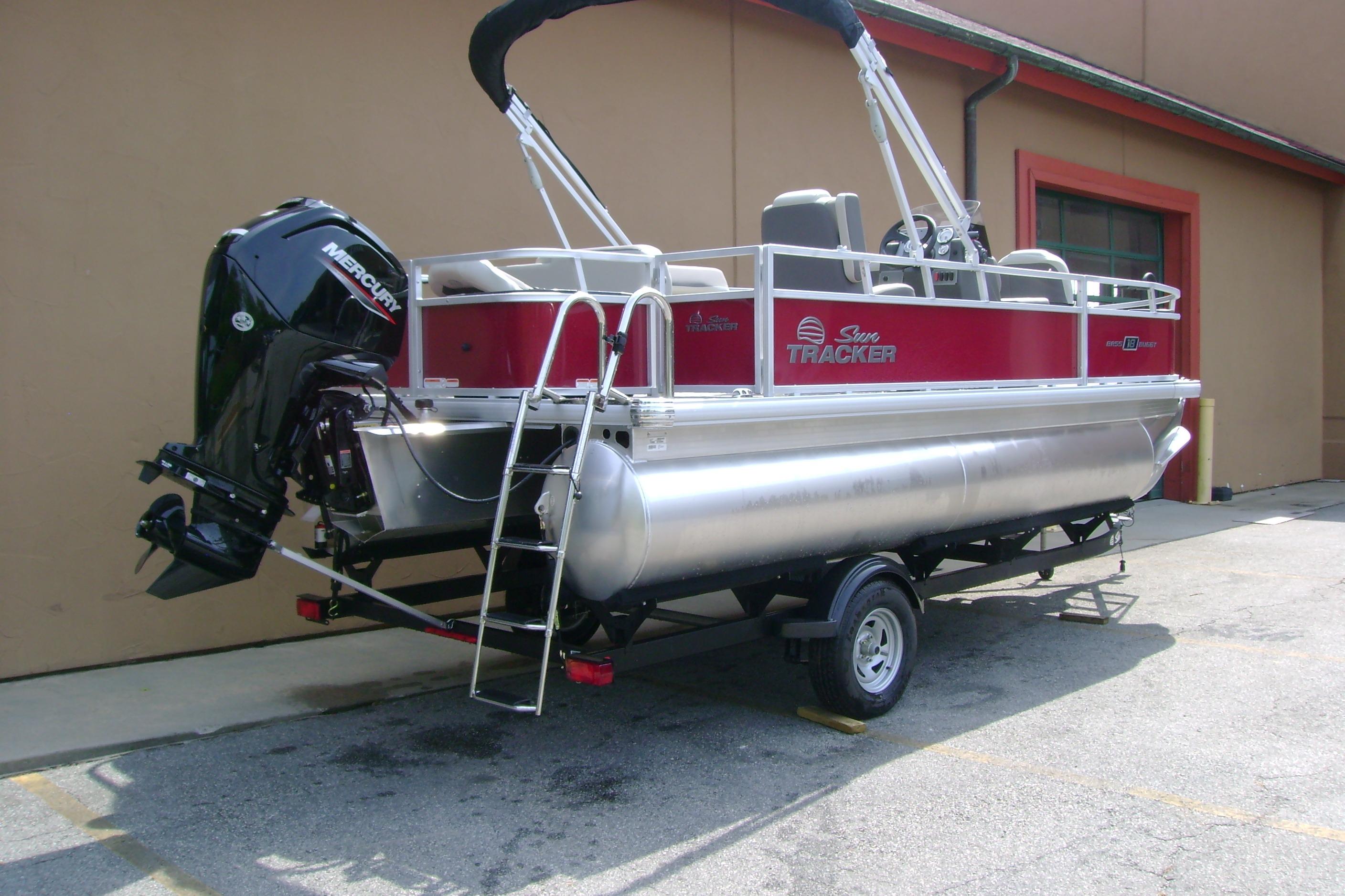 2026 Sun Tracker Bass Buggy 18 DLX pontoon boat with Mercury outboard motor on trailer.