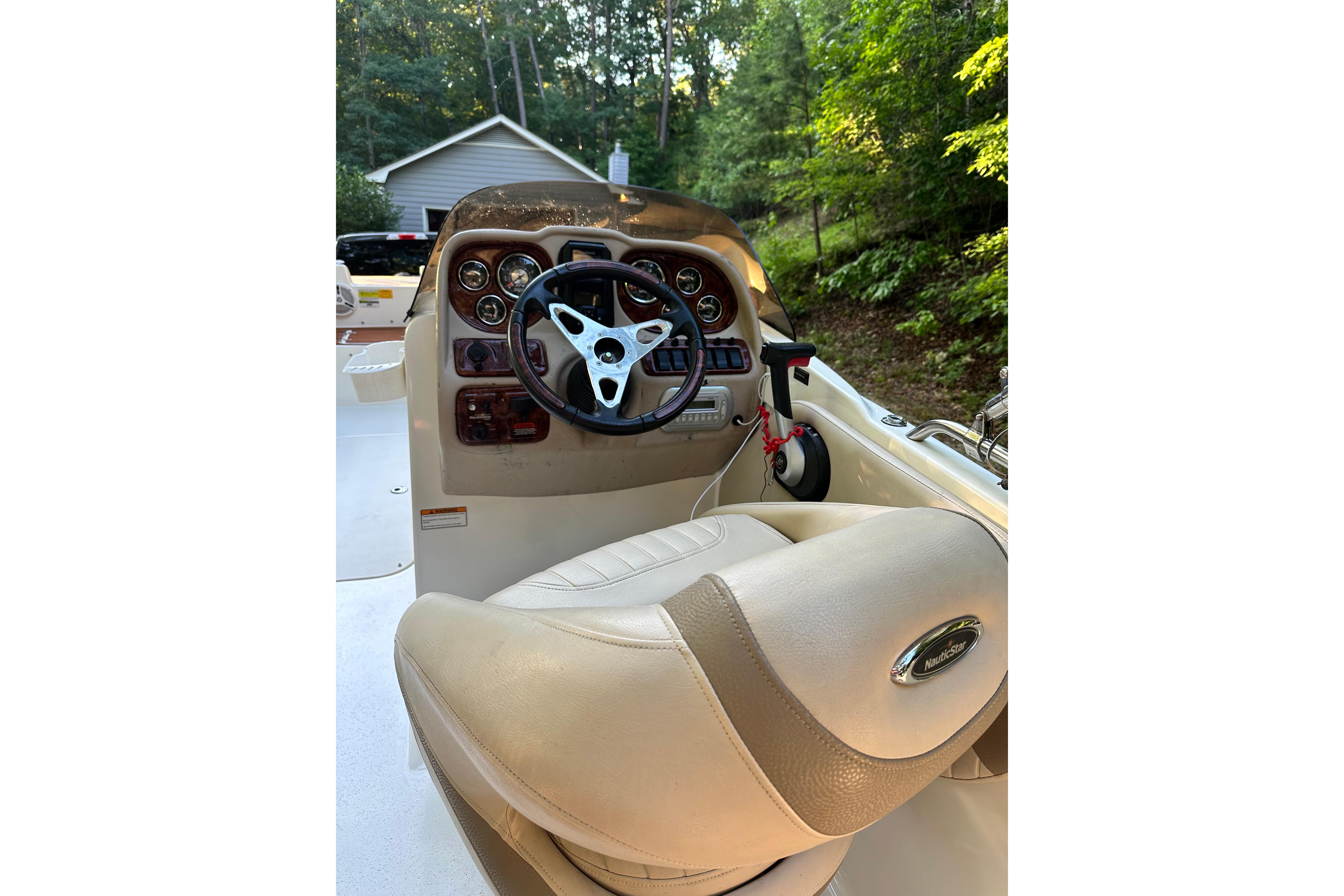 2008 NauticStar 230 SL Sport Deck I/O boat cockpit with steering wheel and controls.