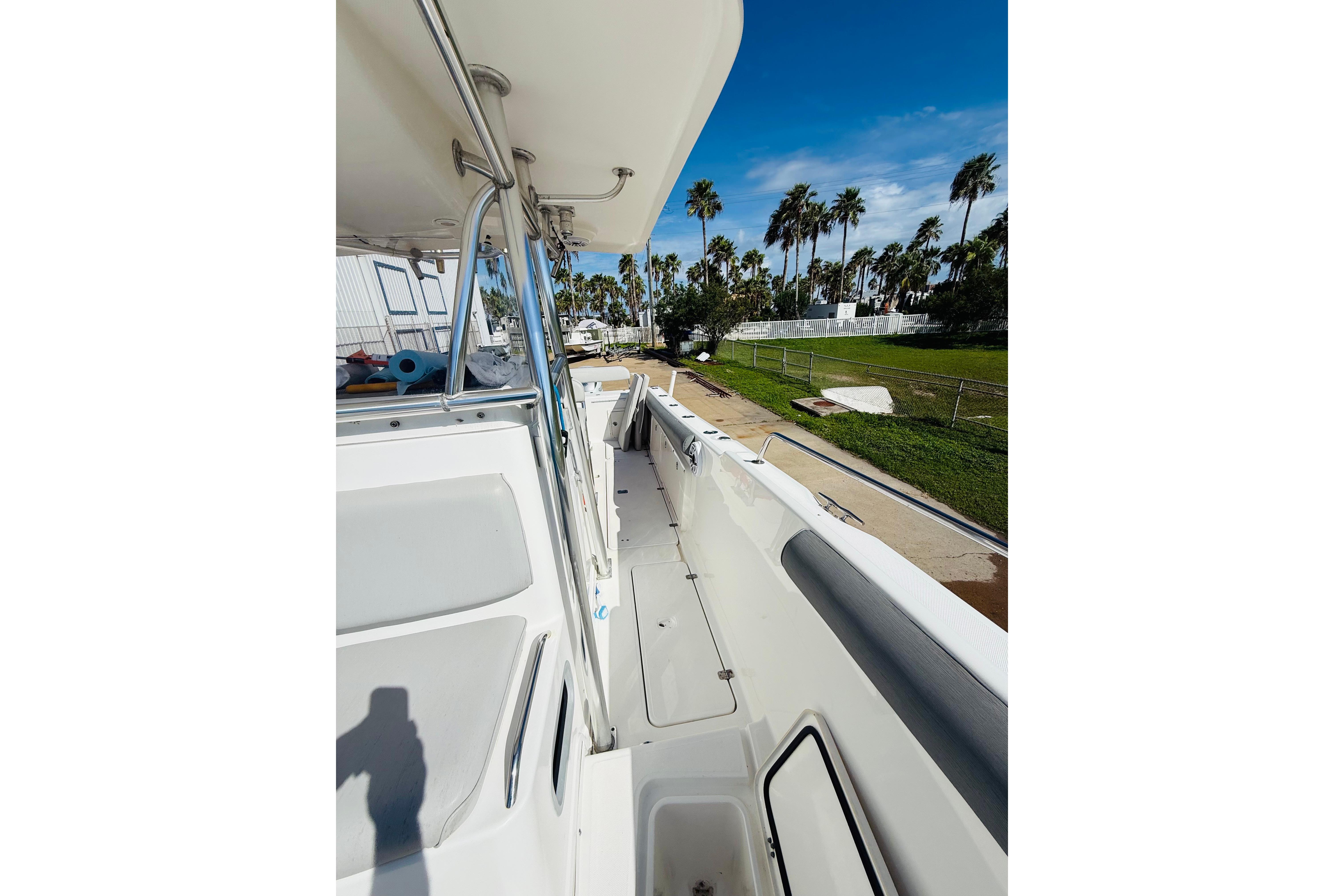 2005 Century 3200 Center Console boat with spacious deck, palm trees in background.