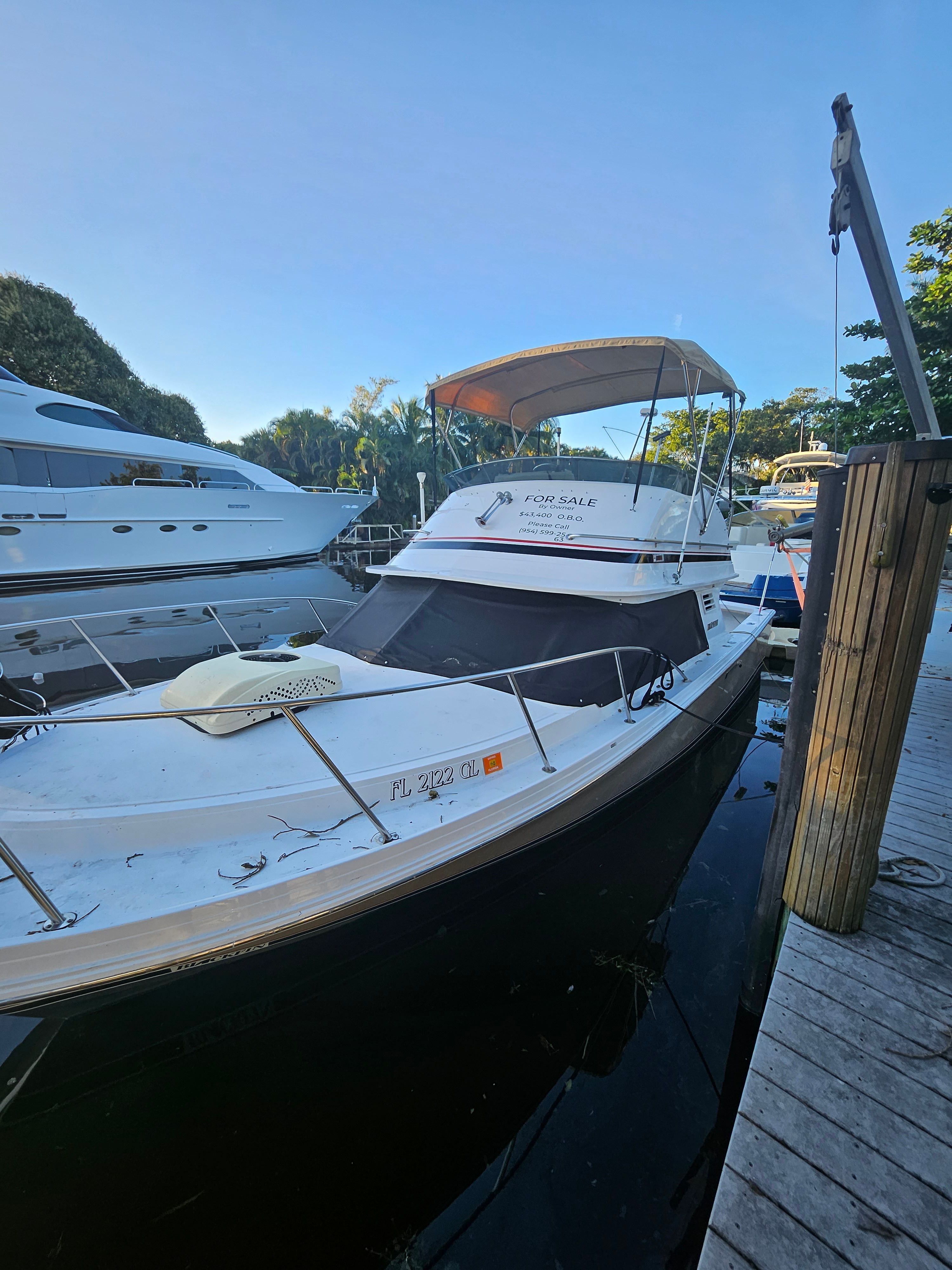 A 1990 Blackfin 29SF boat docked. It features a sunshade and is for sale.