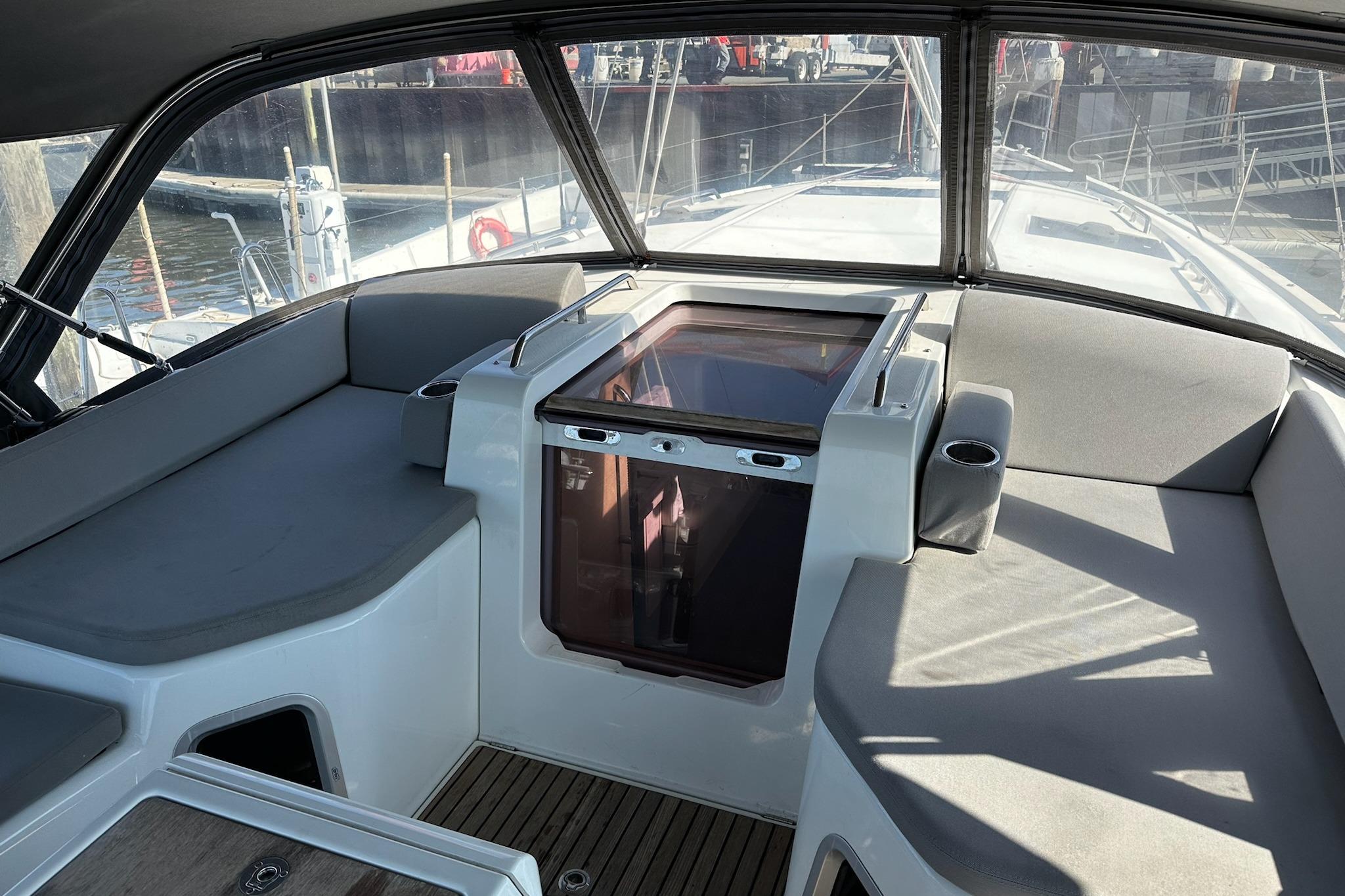 2018 Jeanneau 51 yacht cockpit with cushioned seating and wooden flooring.