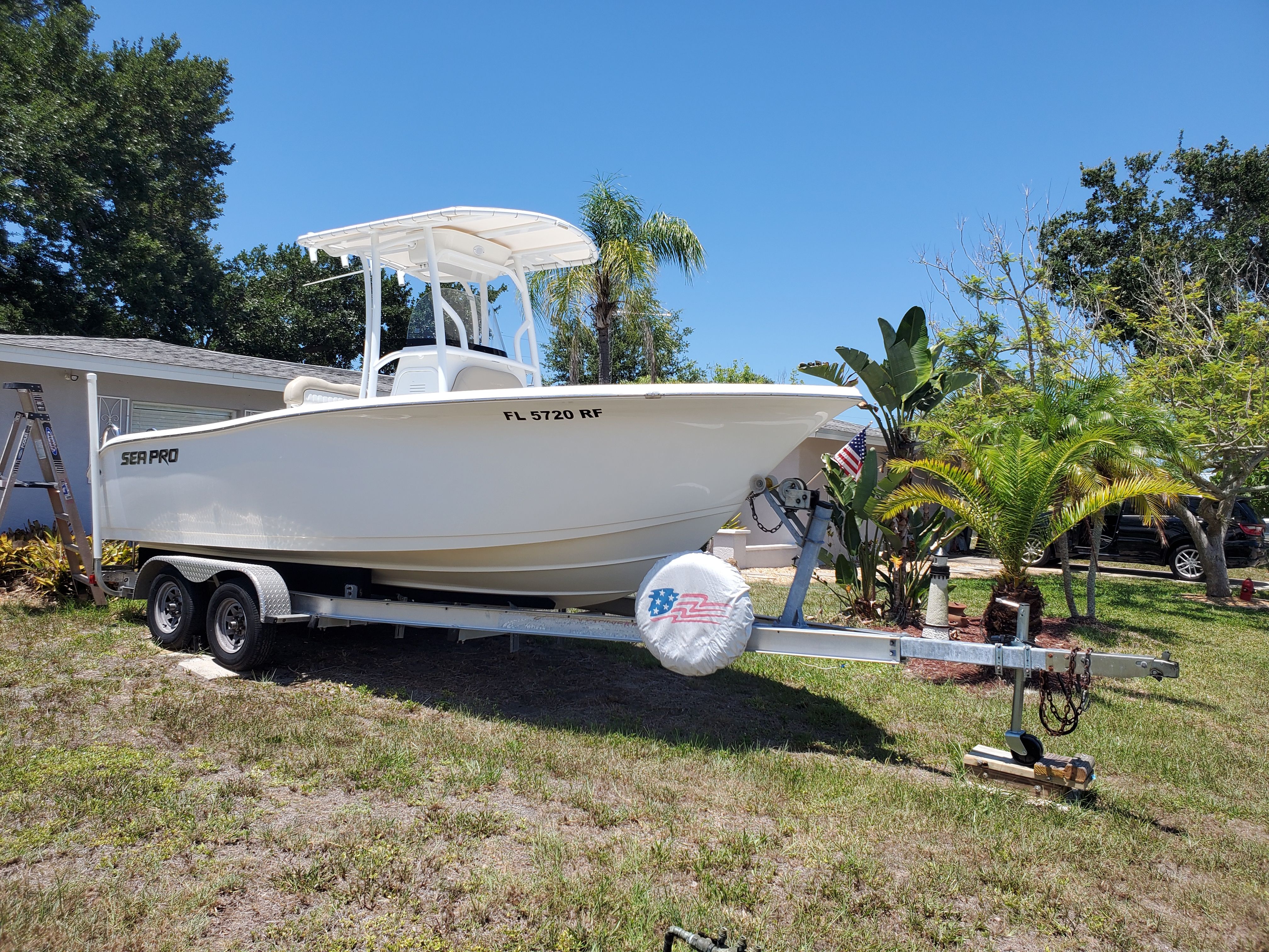 A 2017 Sea Pro 219 Center Console boat on a trailer, surrounded by palm trees.