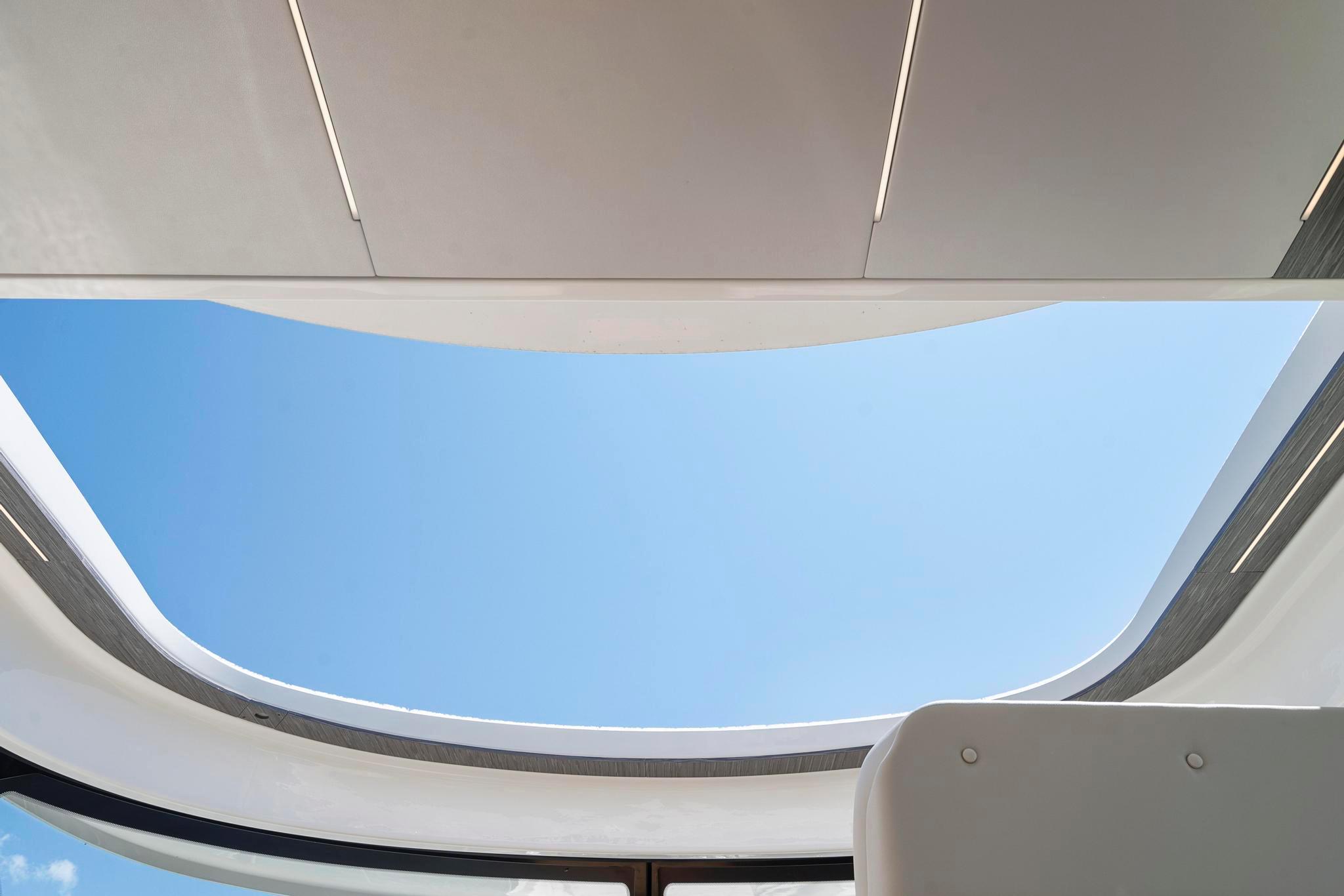 Open sunroof view on 2022 Tiara Yachts C49 Coupe, showcasing clear blue sky.