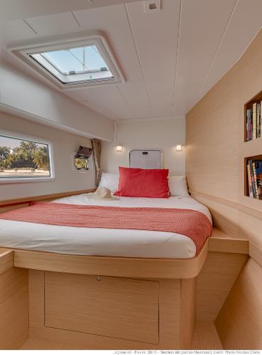Luxurious cabin interior of 2025 Lagoon 42 Millenium yacht with cozy bed and natural light.