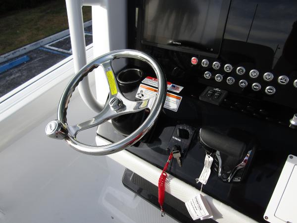 Steering console of 2025 Wellcraft 243 Fisherman boat with controls and display.