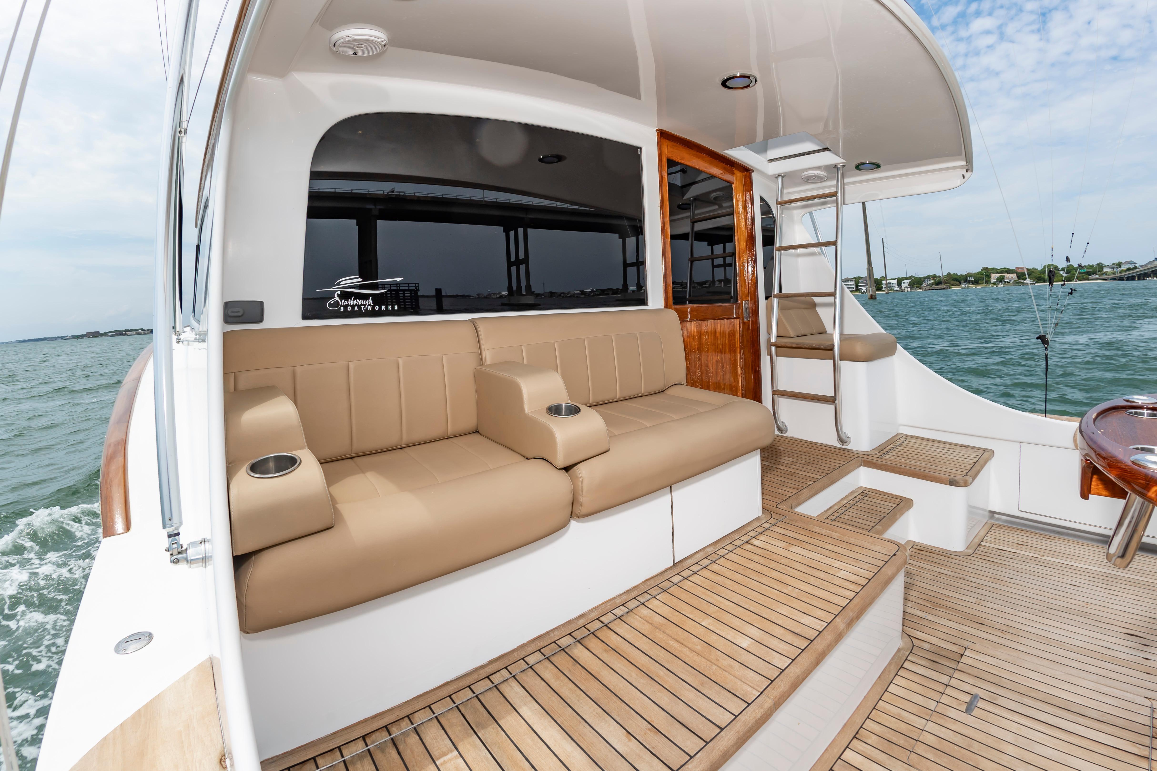 Luxurious 1993 Custom Carolina Scarborough 56 Convertible yacht interior with tan seating and ocean view.