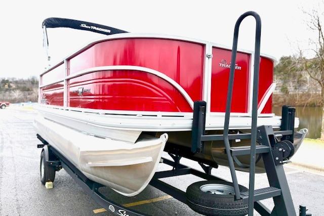 2026 Sun Tracker Party Barge 18 DLX pontoon boat on trailer, red exterior.