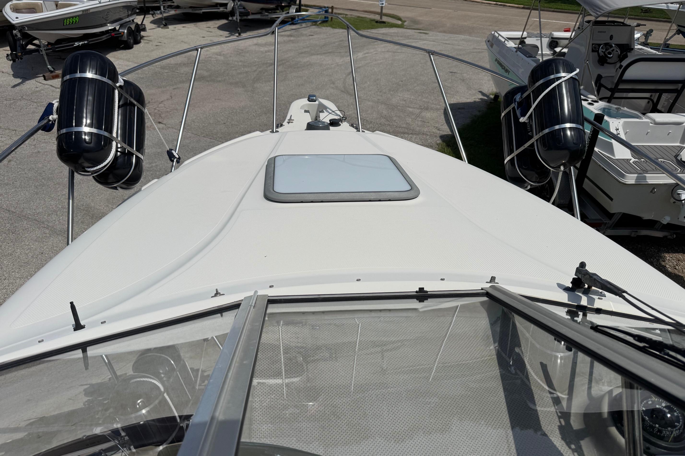 2000 Maxum 2400 SCR boat deck with fenders, docked in a marina.