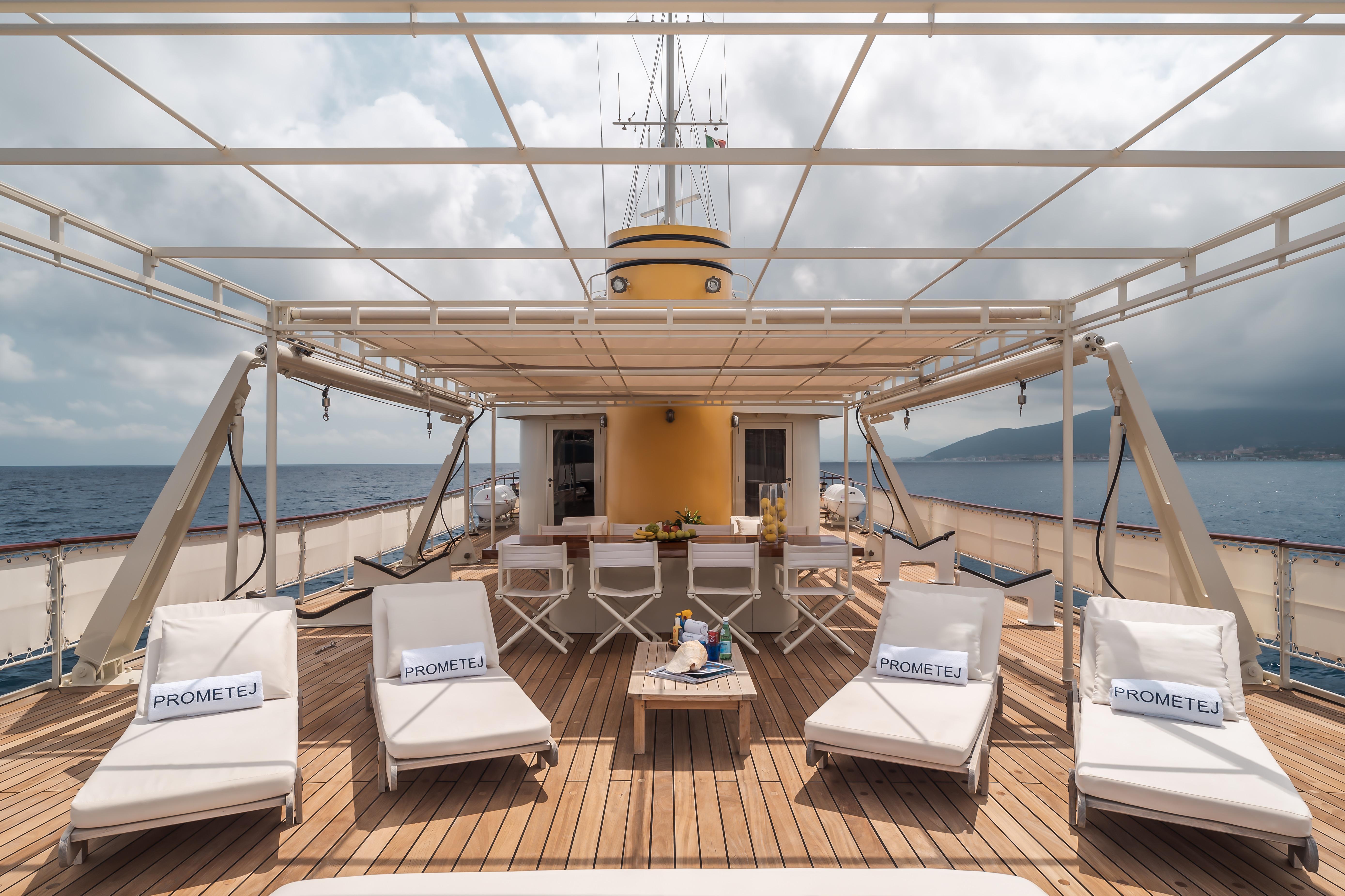 Luxurious deck of 1956 custom converted tugboat with lounge chairs and ocean view.
