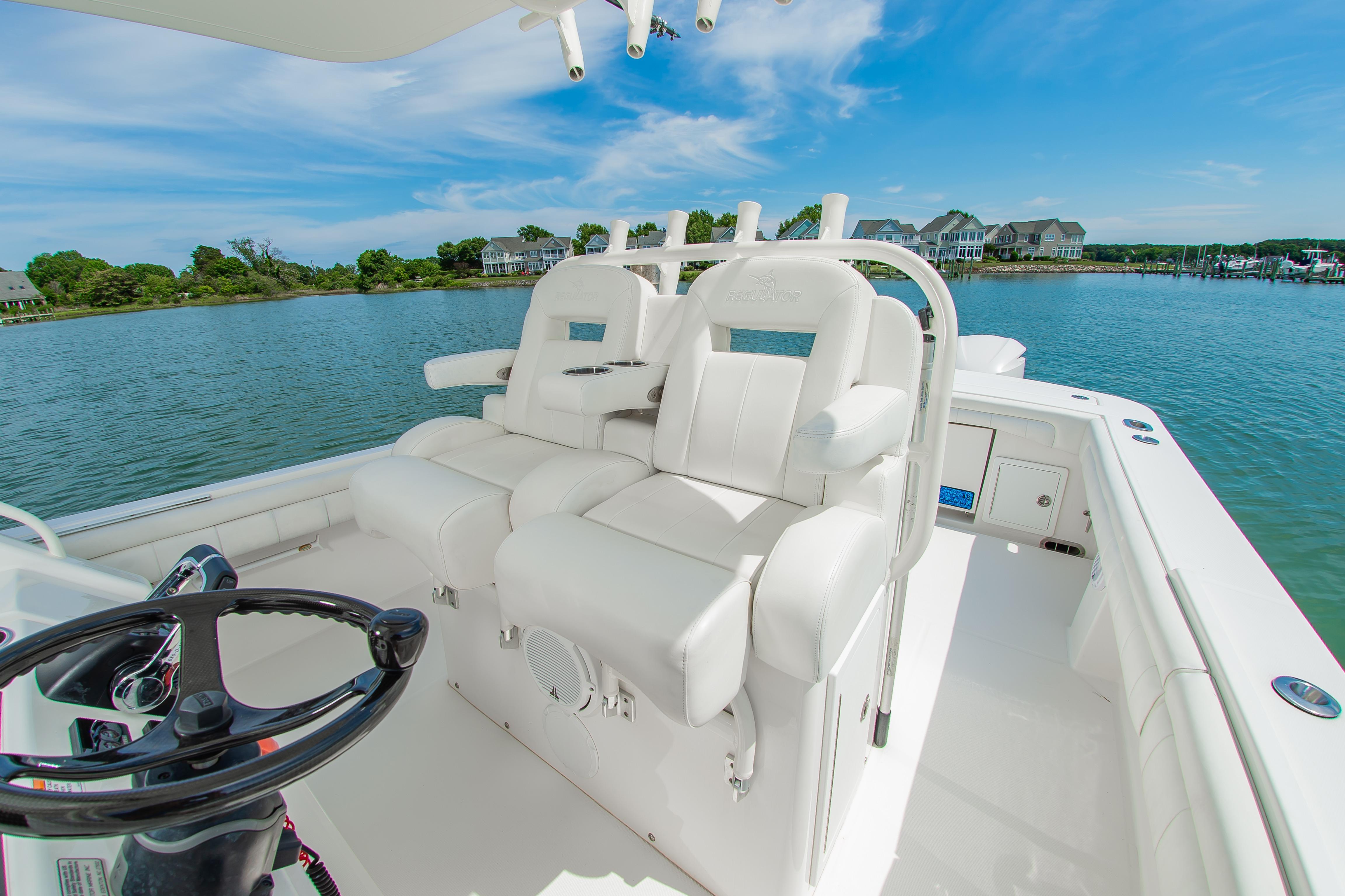 2019 Regulator 31 boat interior with white seating, steering wheel, and scenic waterfront view.