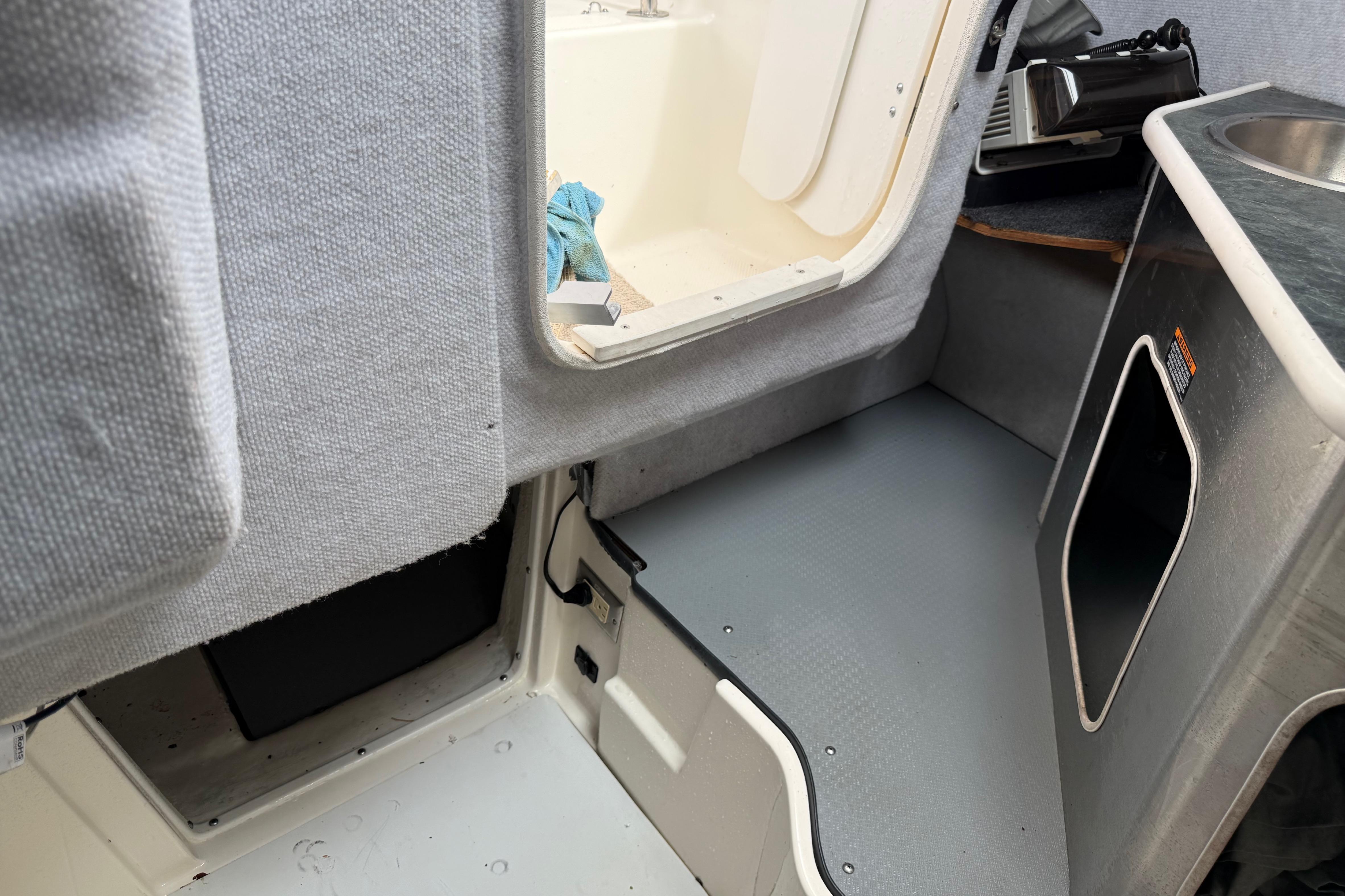 Interior of a 2006 Trophy 2502 Walkaround boat, featuring cabin entry and sink area.