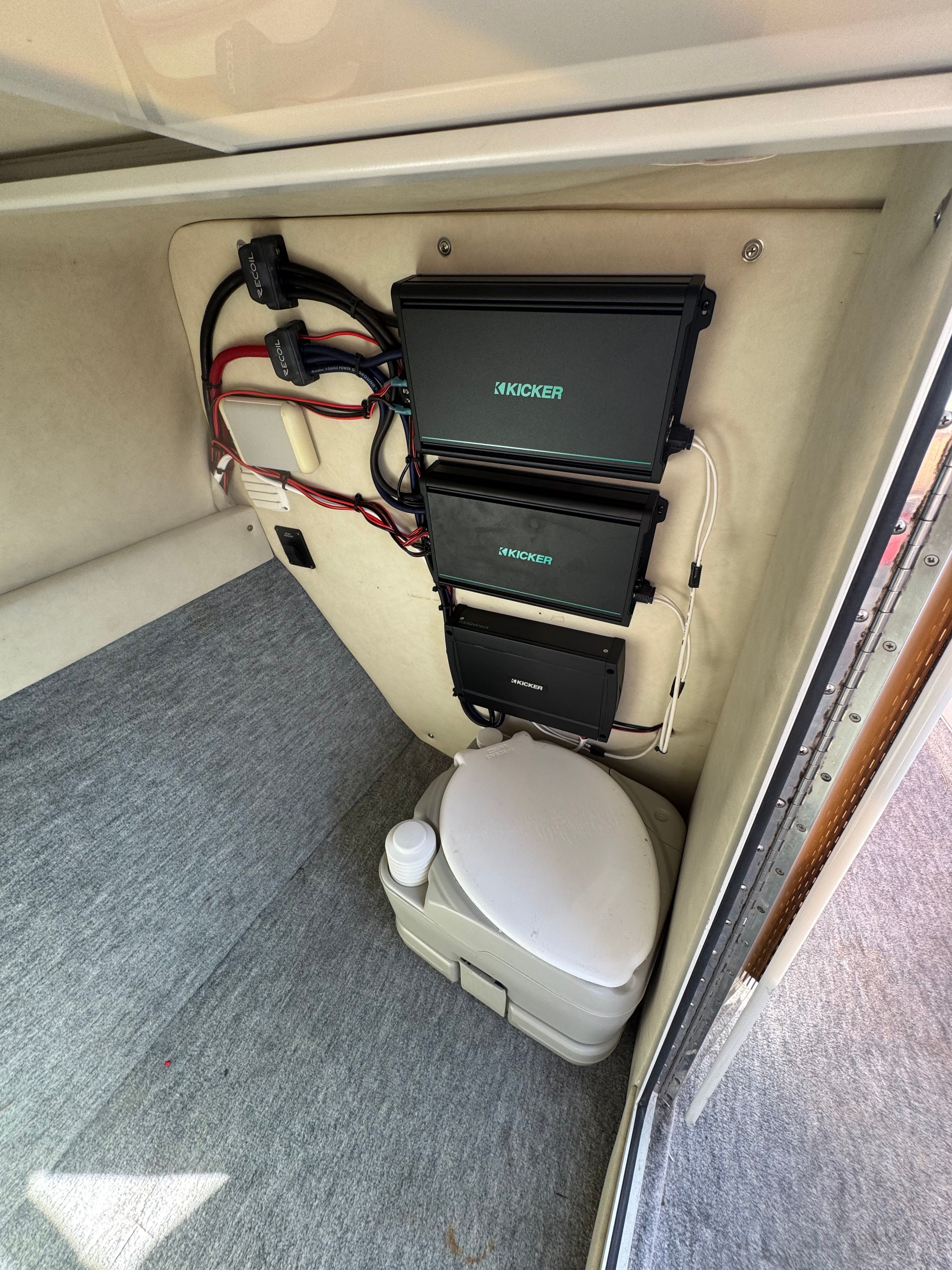 Interior of a 1994 Crownline 266 BR boat with toilet and Kicker amplifiers.