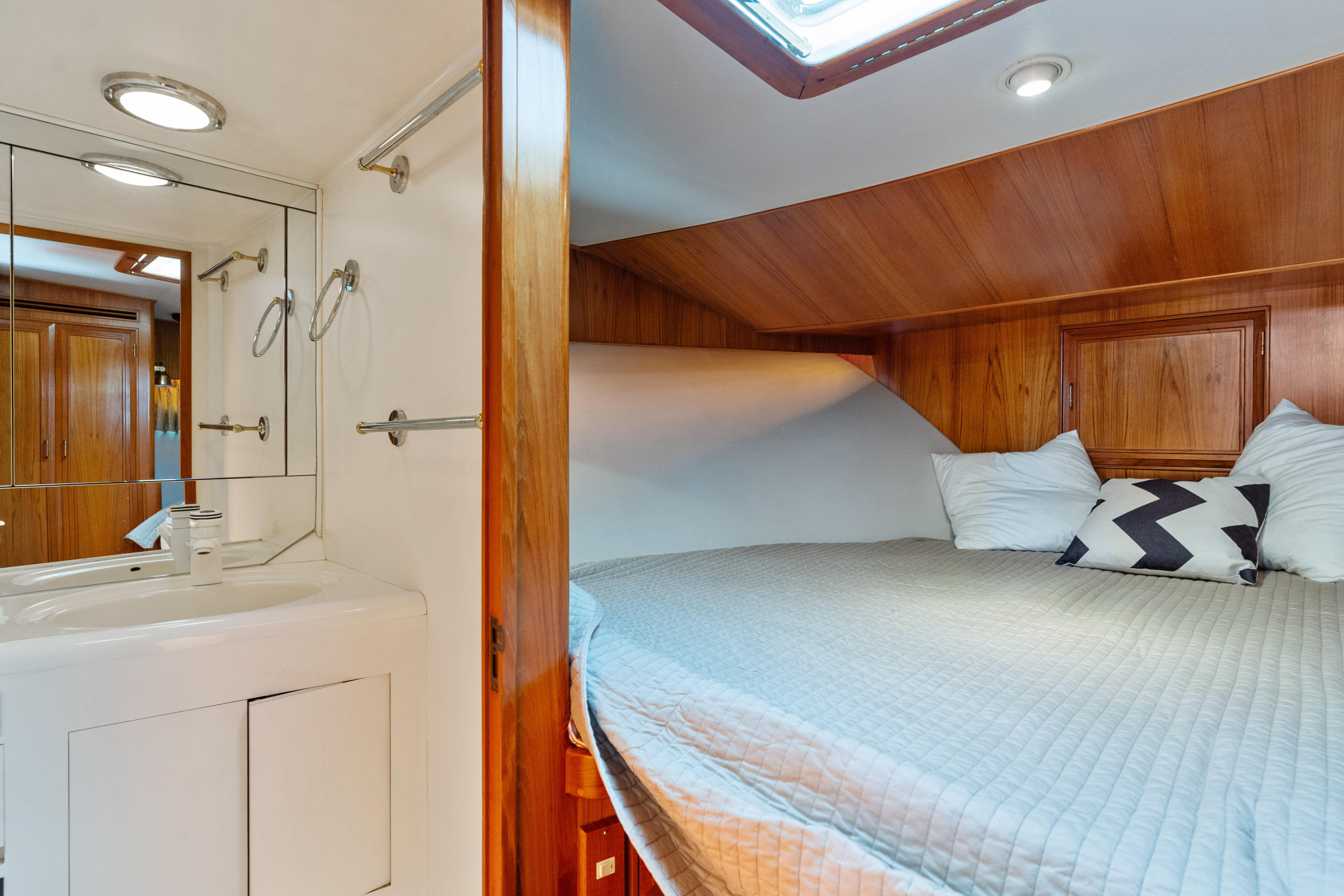 Cozy cabin interior of 1993 Ocean Alexander 440 yacht with bed and vanity.