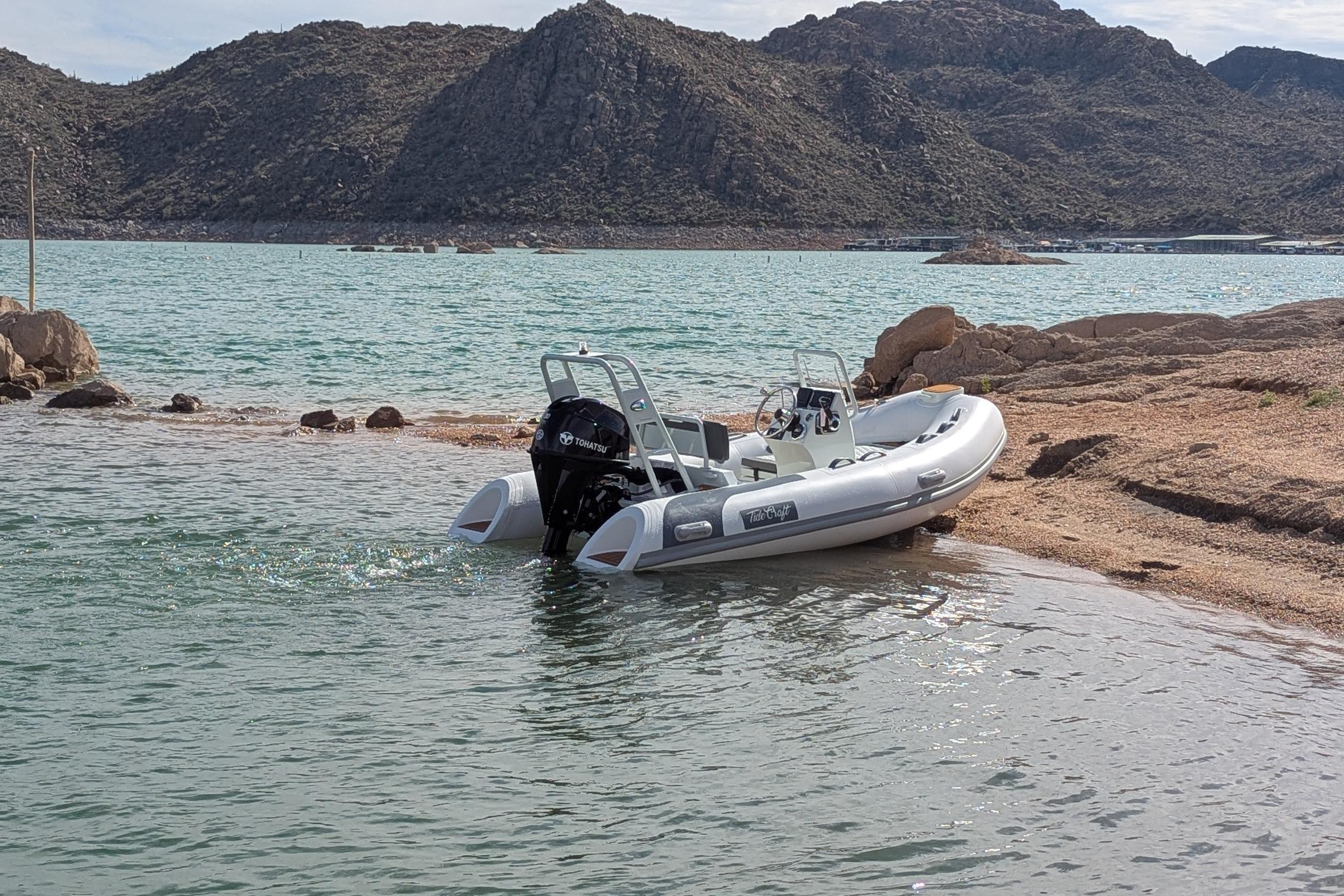 Tide Craft San Juan 11 boat docked on a rocky lakeshore, 2027 model.