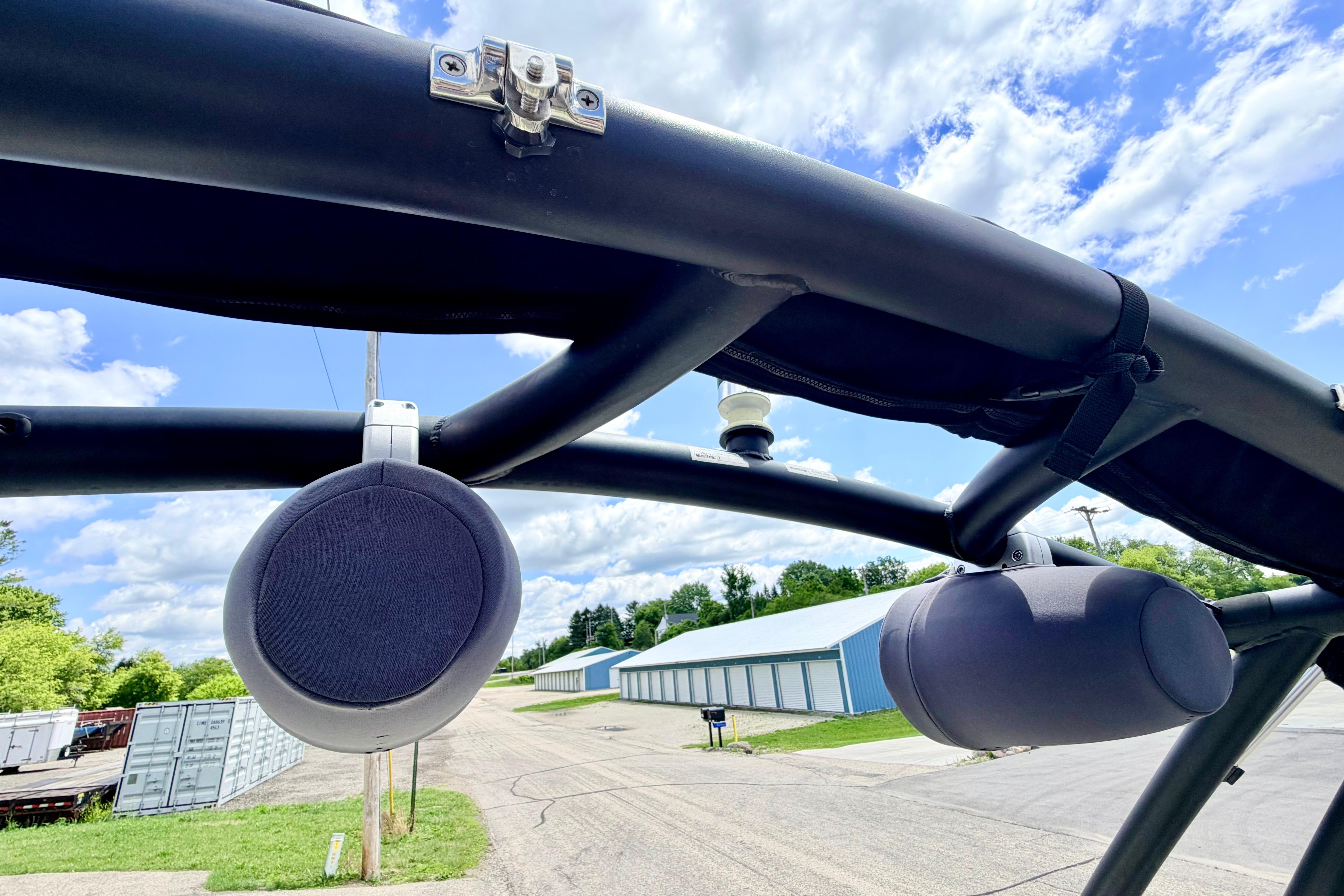 Speakers mounted on a 2018 Glastron GT 185 boat against a blue sky background.