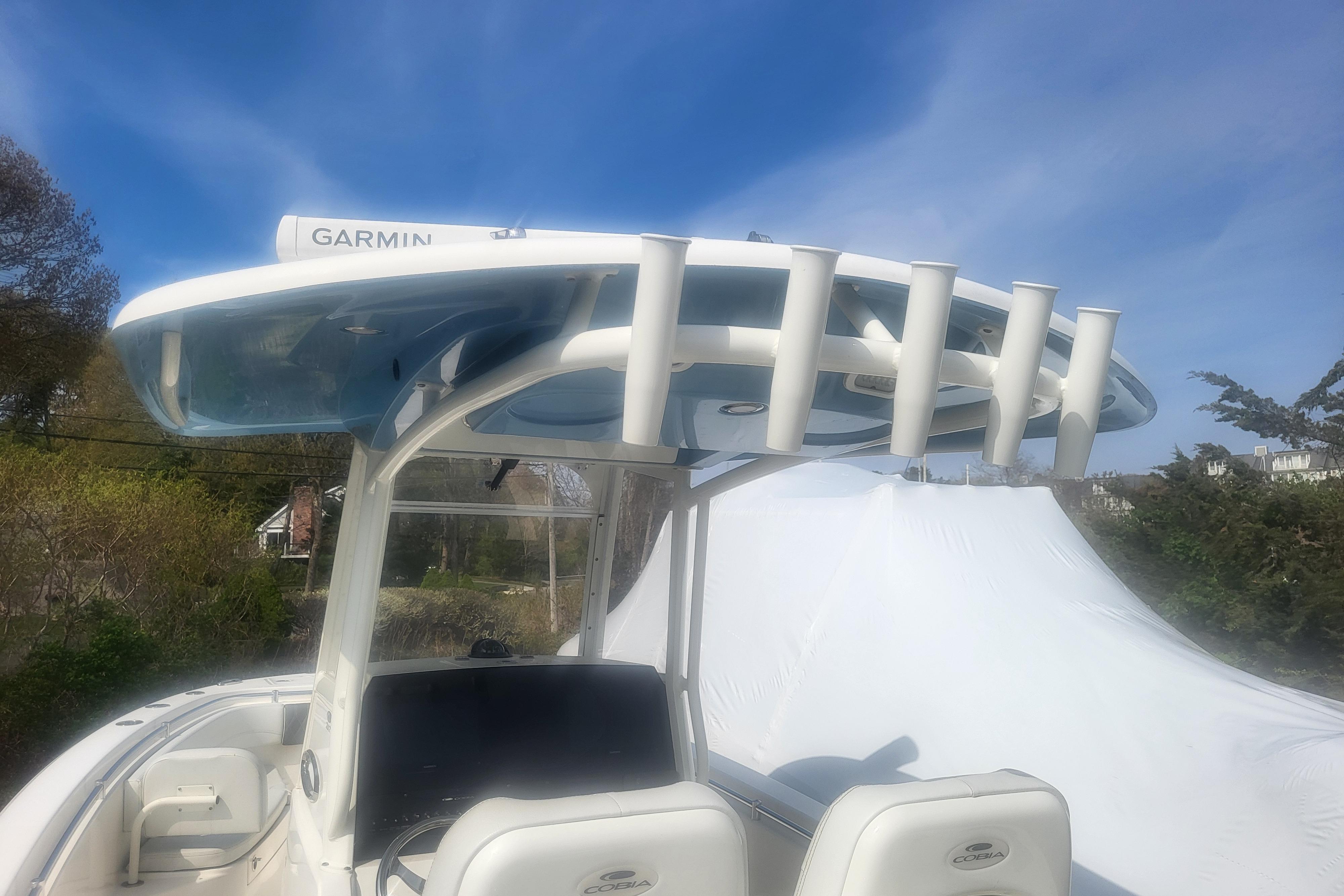 2022 Cobia 262 Center Console boat with Garmin equipment under a clear blue sky.