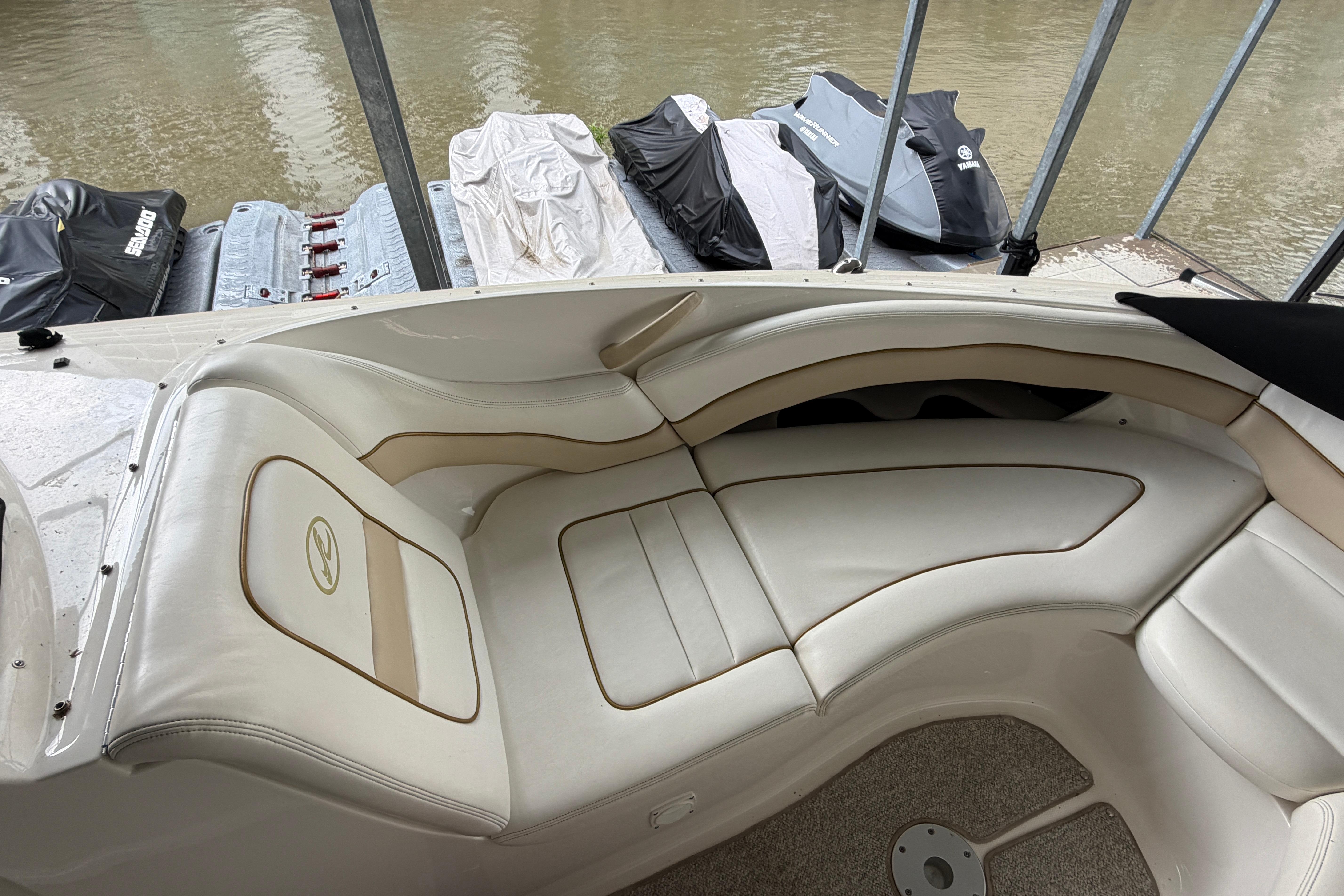 2003 Sea Ray 290 Bowrider interior with white leather seating and docked jet skis.