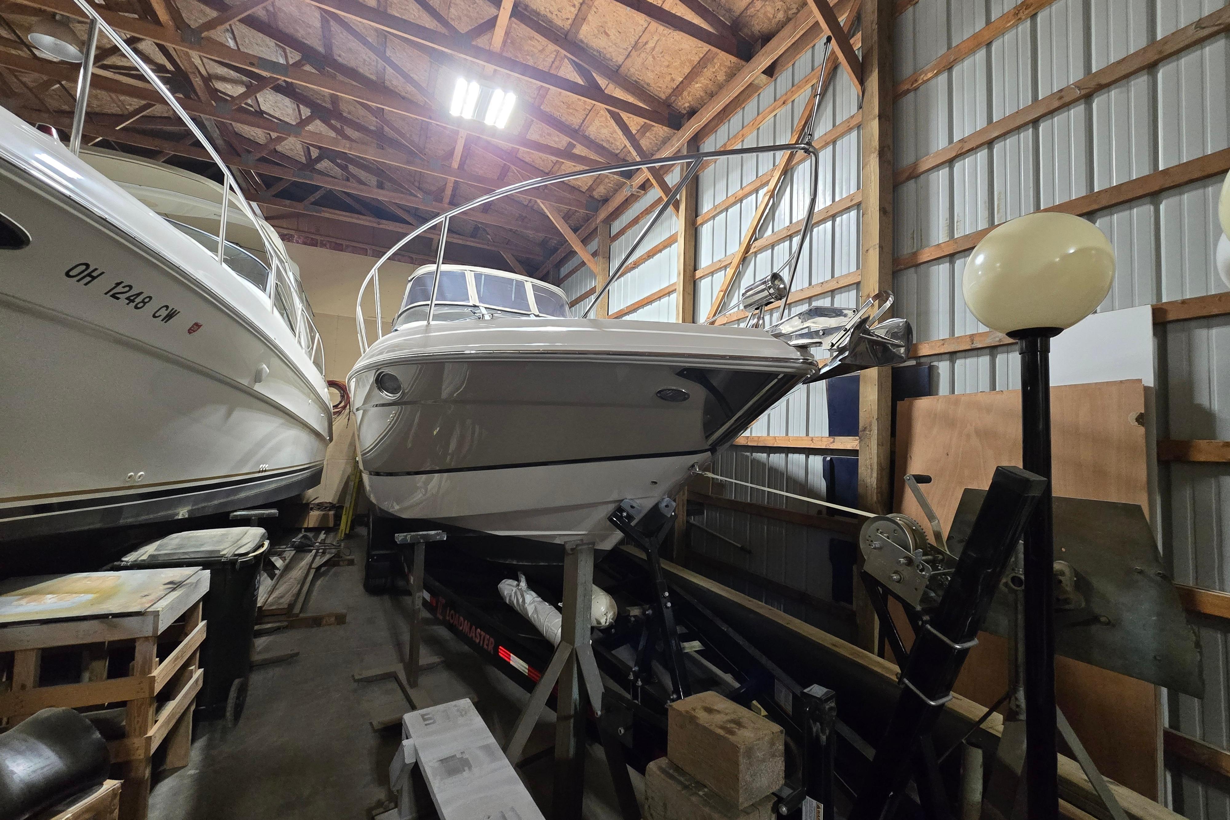2008 Regal 3060 Window Express boat stored indoors, surrounded by wooden beams and equipment.