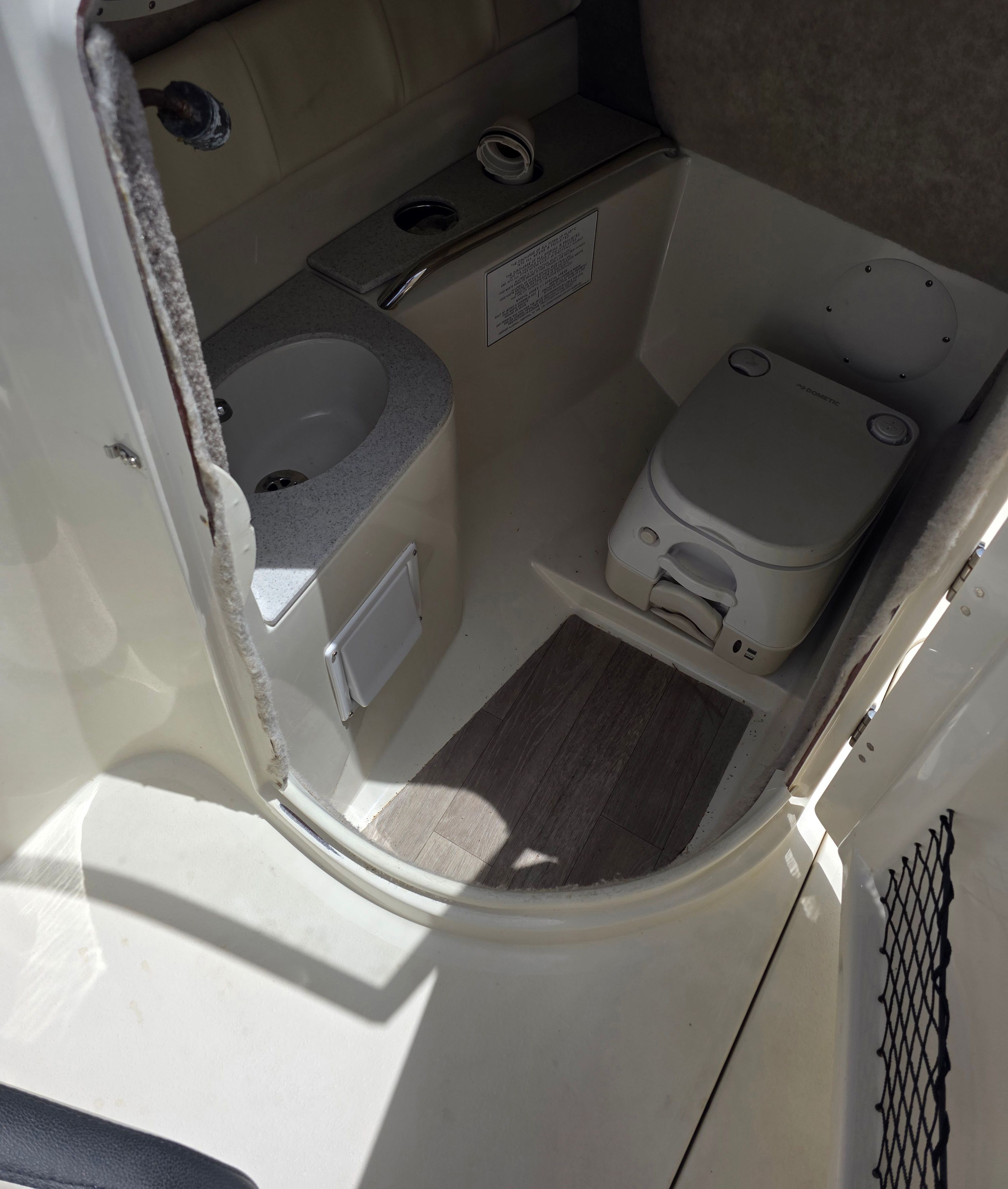 Interior of a boat cabin with a toilet and sink.