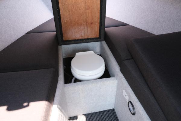 2023 Makaira Gen3 800 boat interior with compact toilet and cushioned seating.