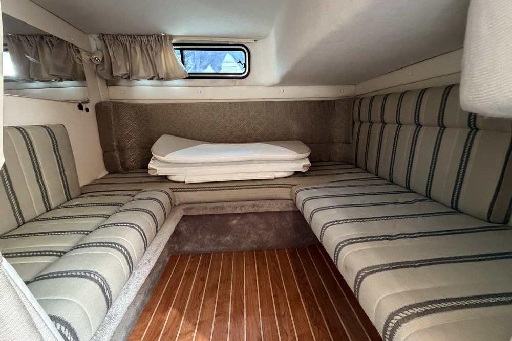 Interior cabin of a 2001 Monterey 282 Cruiser with striped seating and wooden flooring.