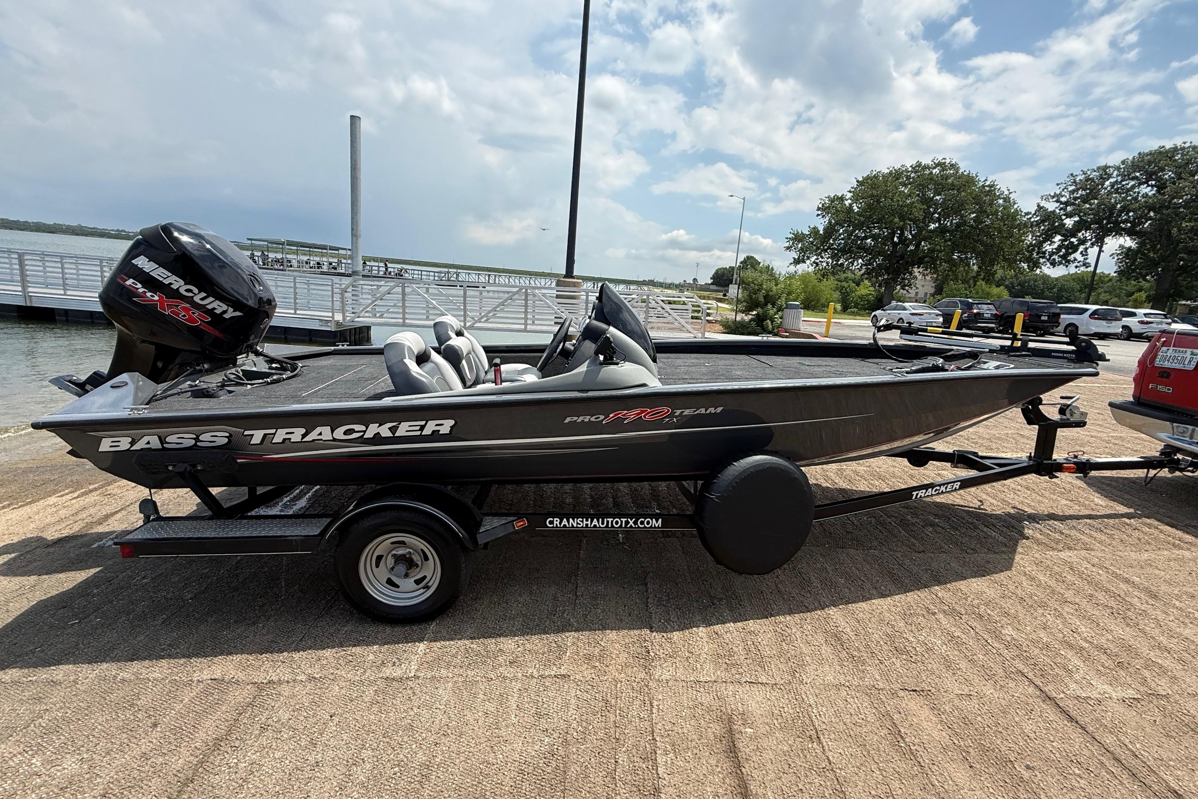 2015 Tracker Pro Team 190 TX bass boat on trailer by a lake.