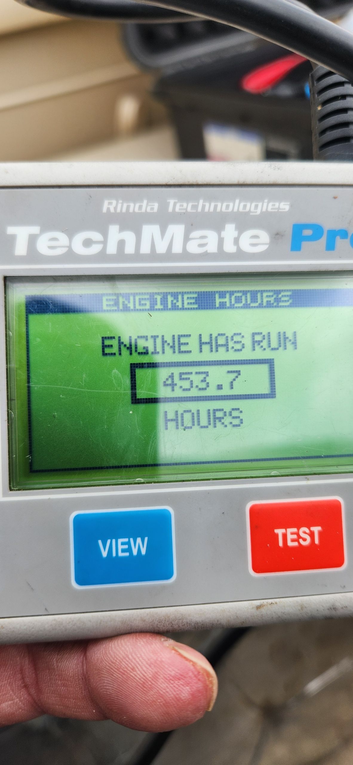 A TechMate Pro displays 453.7 engine hours.