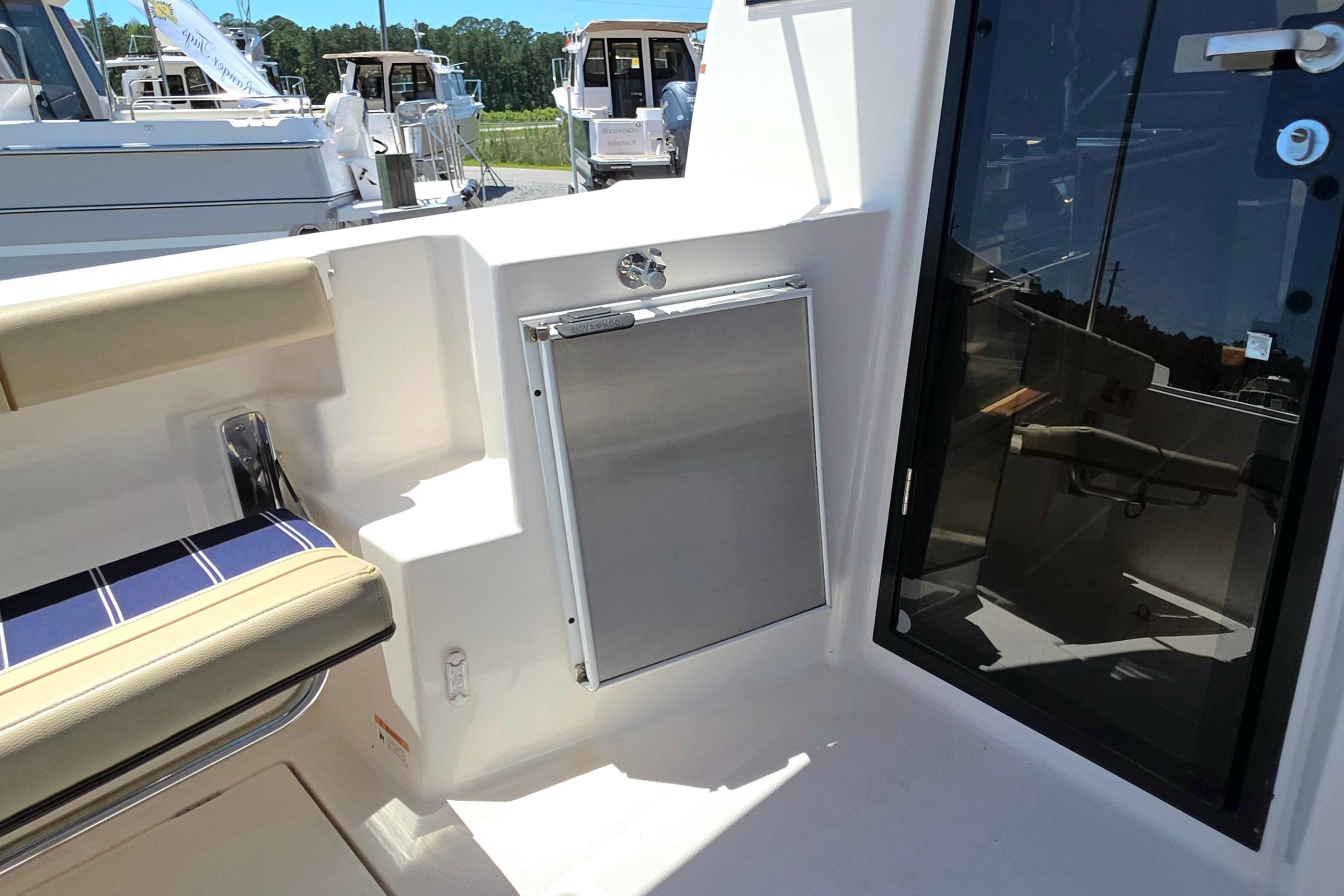 2021 Ranger Tug R27 boat interior with seating and door, showcasing modern design.