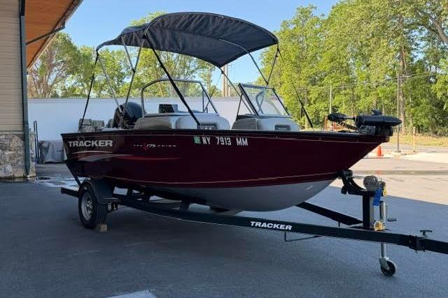 2017 Tracker Pro Guide V-175 Combo boat on trailer with canopy, parked outdoors.