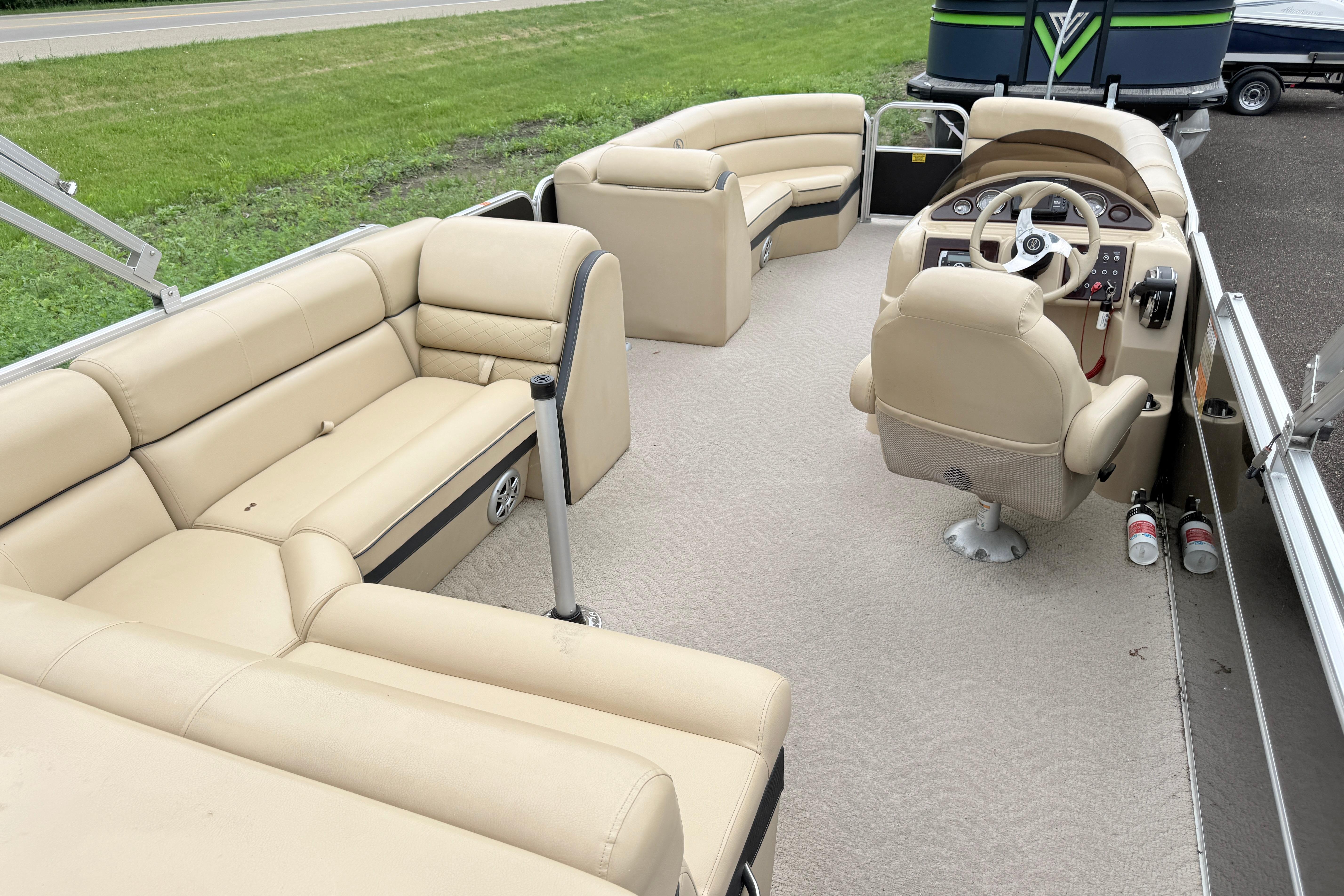 2013 South Bay 522CR pontoon boat interior with beige seating and steering console.