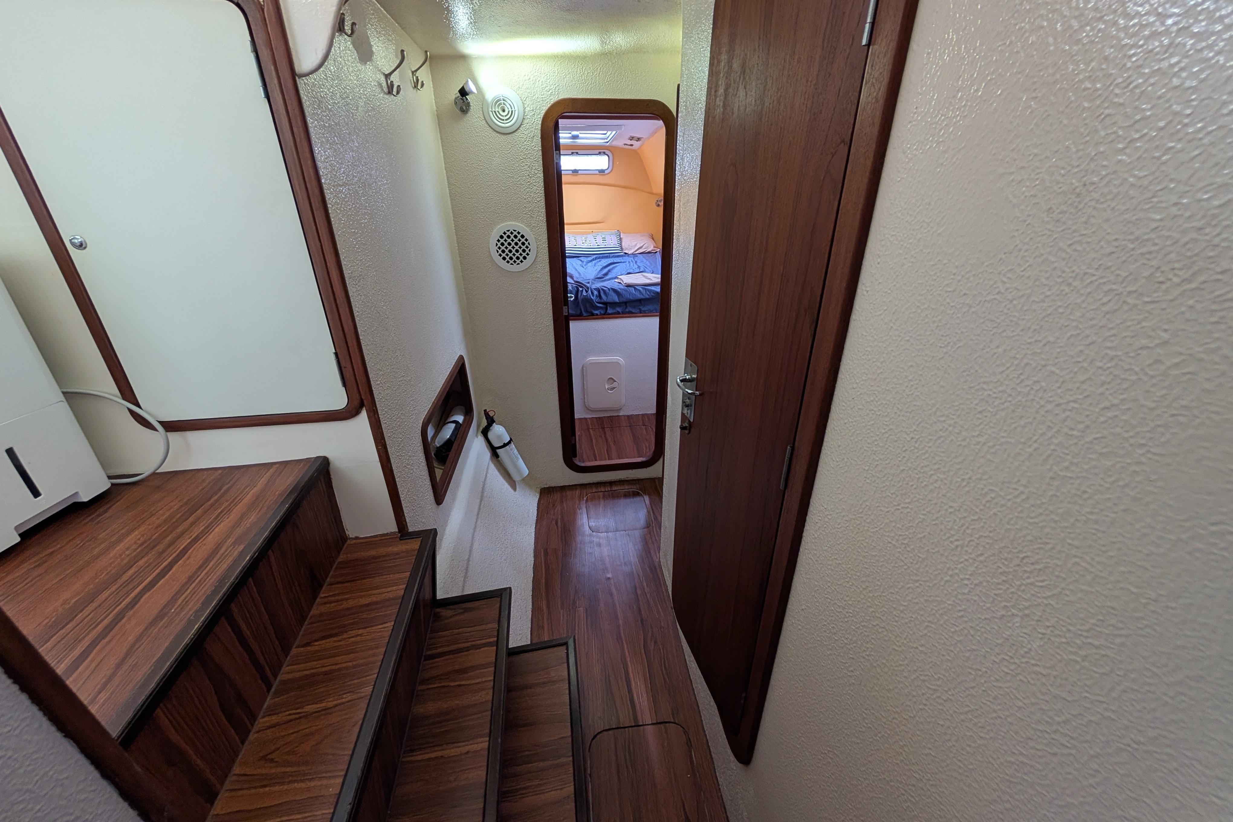 Interior of 1999 Island Spirit 37 yacht, featuring wooden stairs and cozy cabin.