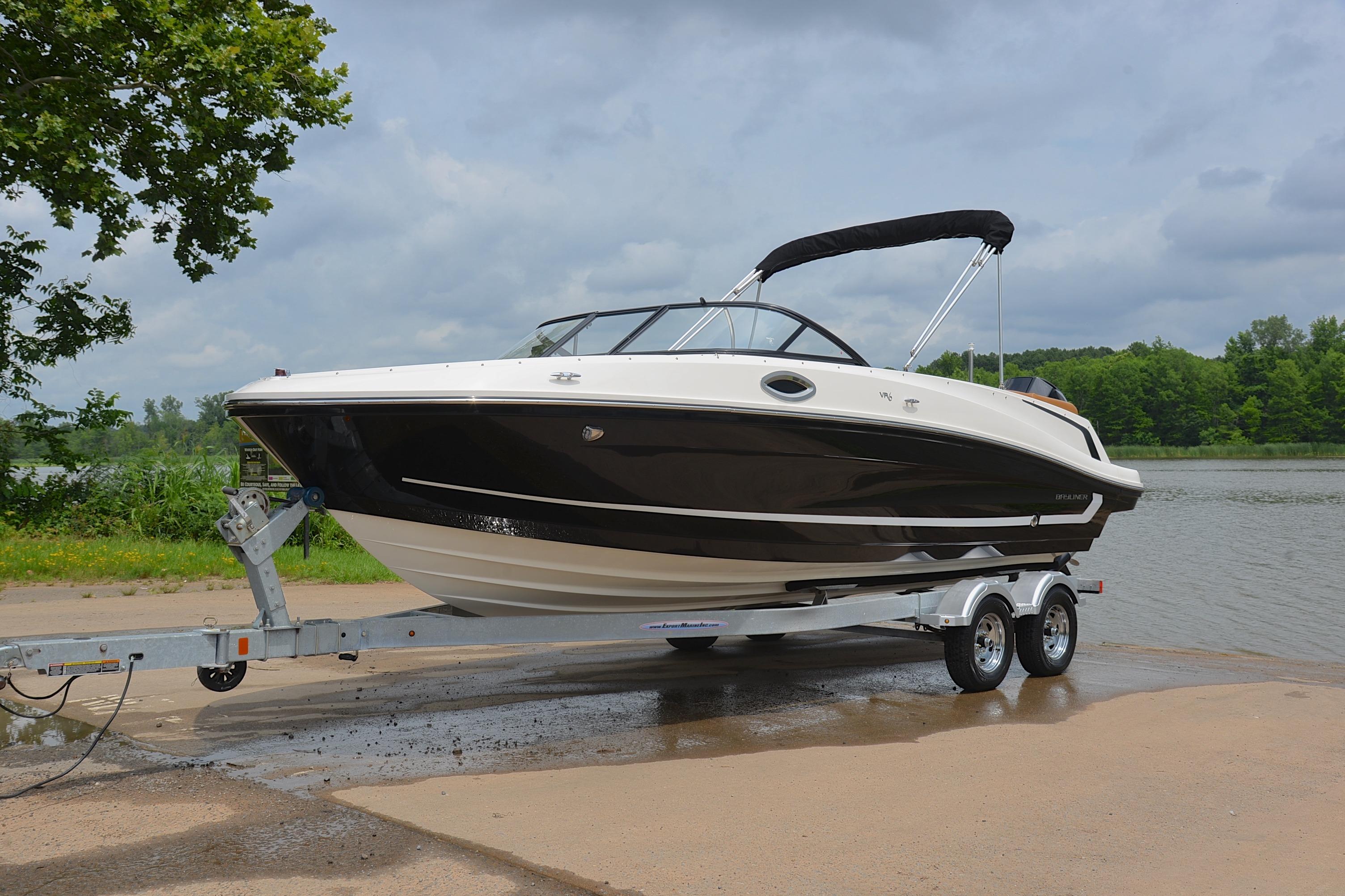2019 Bayliner VR6 Bowrider OB on trailer by a lake, under cloudy sky.