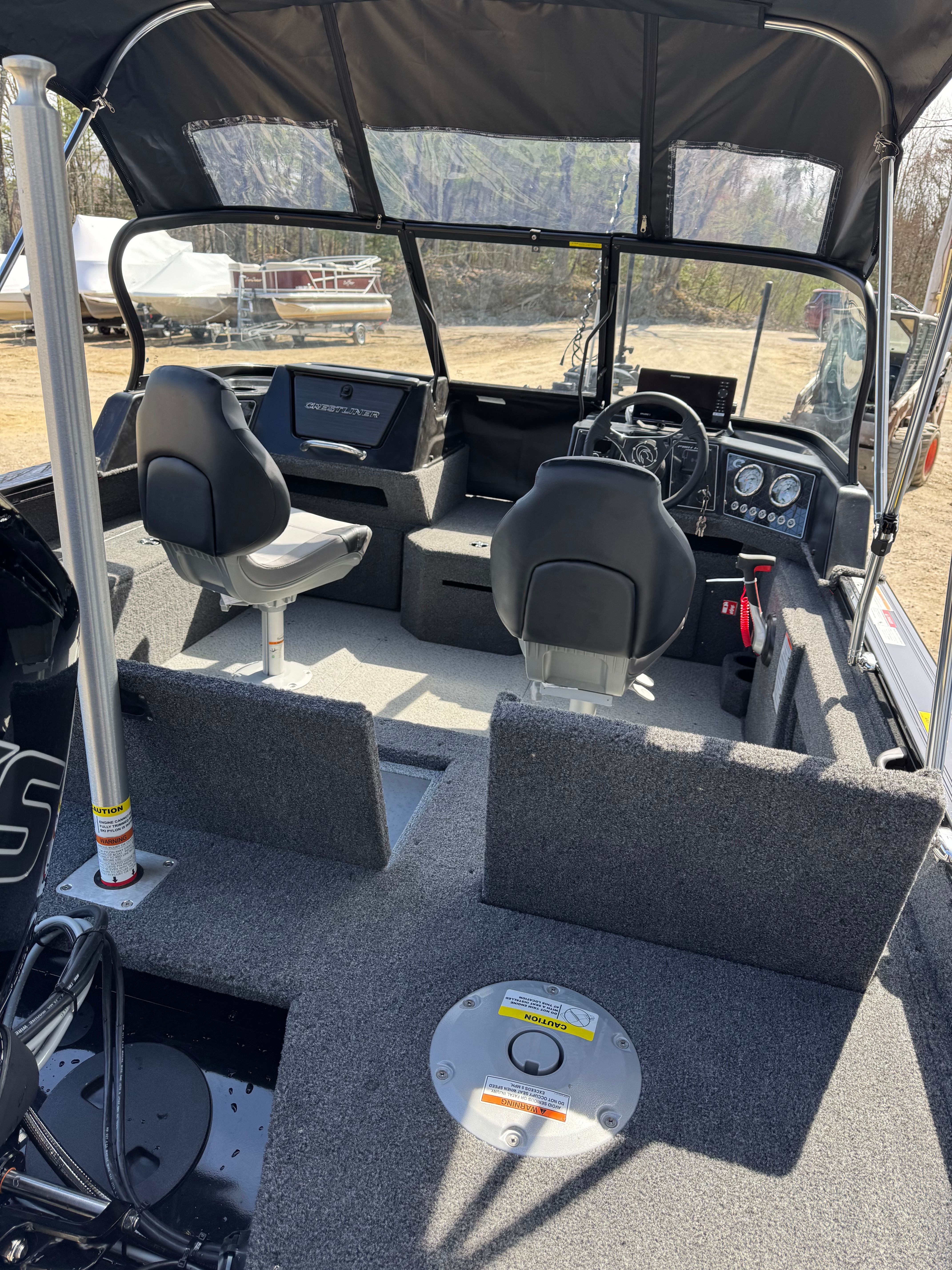 Interior view of a modern fishing boat with two seats and a steering console.