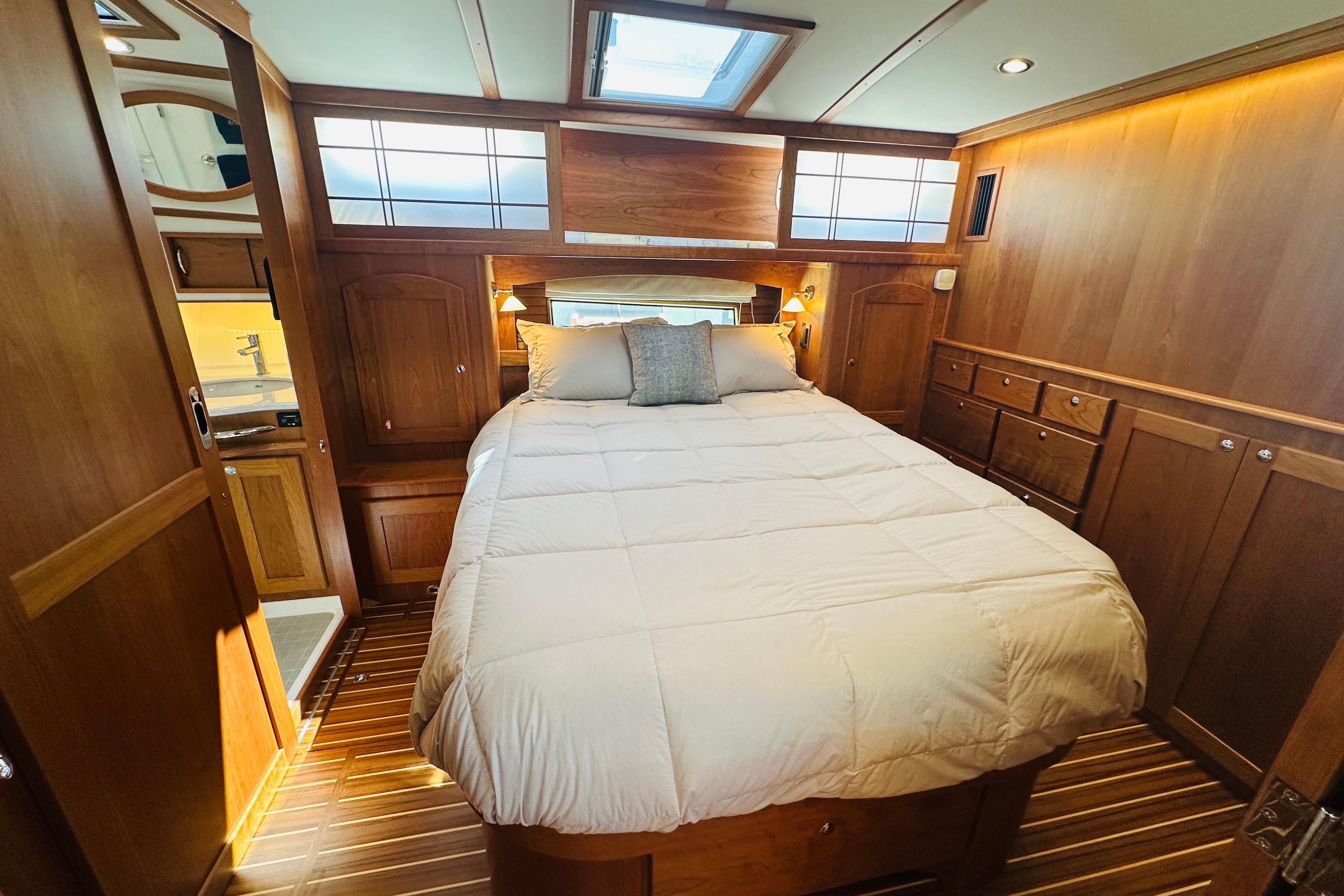 Luxurious bedroom interior of 2025 Sabre 48 Salon Express yacht with wood paneling.