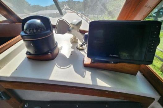 1985 Wasque Down East Cruiser dashboard with compass and Garmin navigation system.