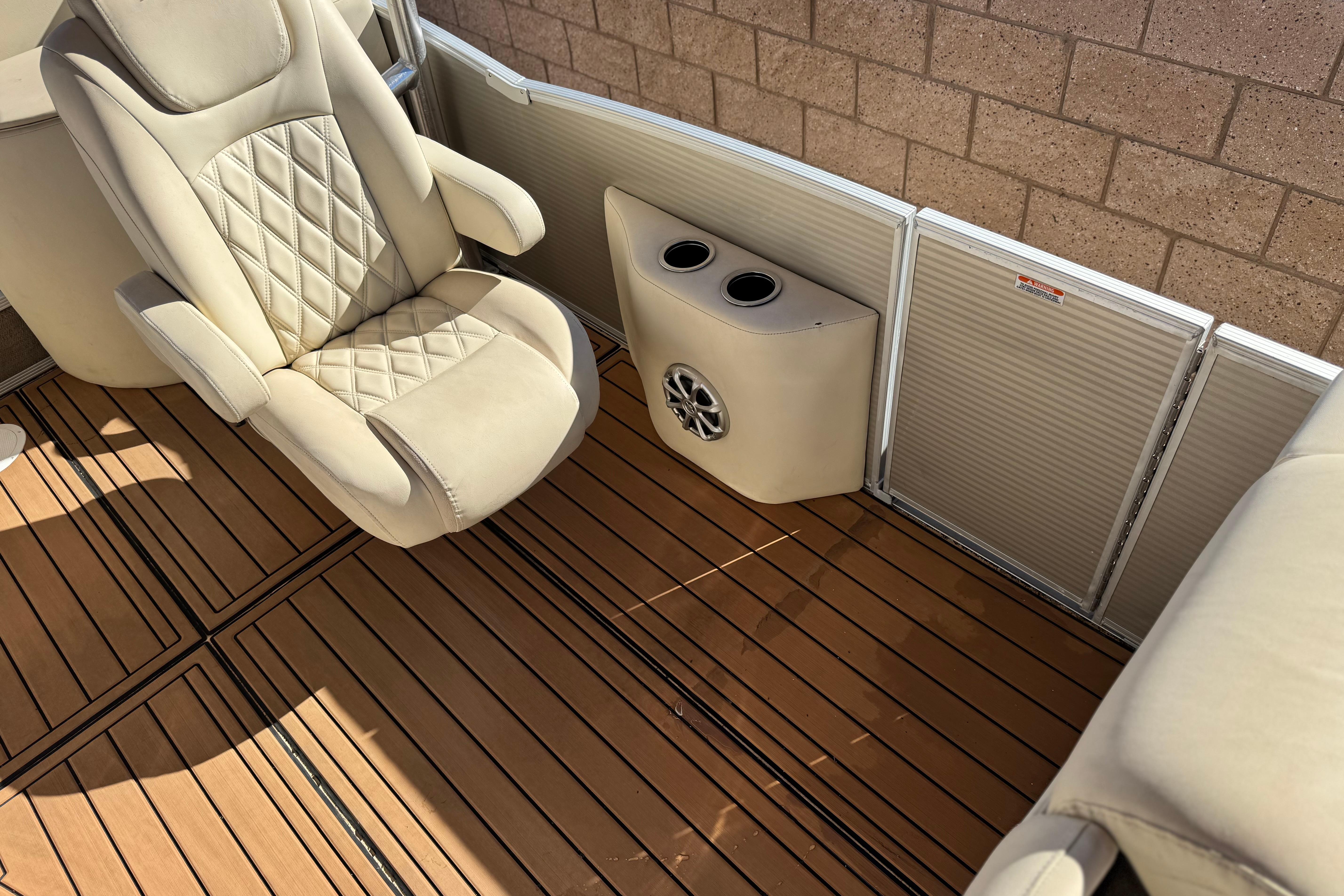 2013 Bennington 2575QCW I/O boat interior with beige seating and wood-style flooring.