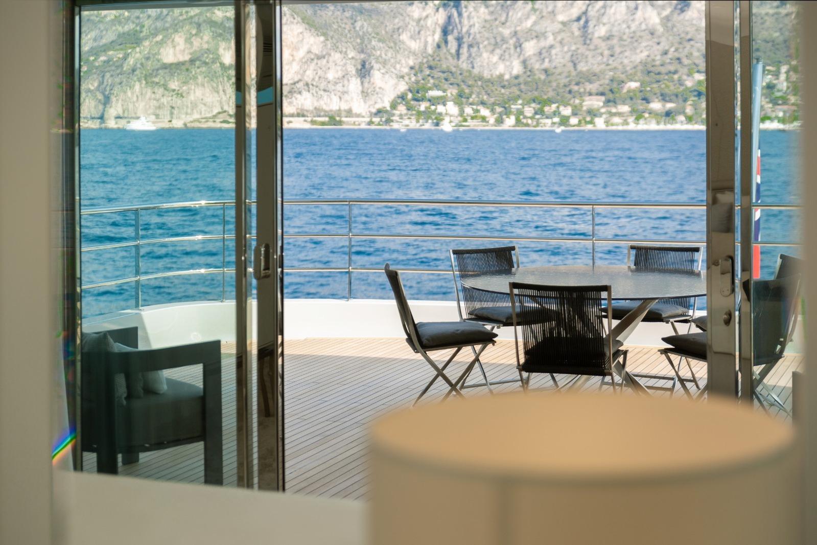 Luxurious Versilcraft 138 yacht deck with ocean view, featuring outdoor seating, 2022 model.
