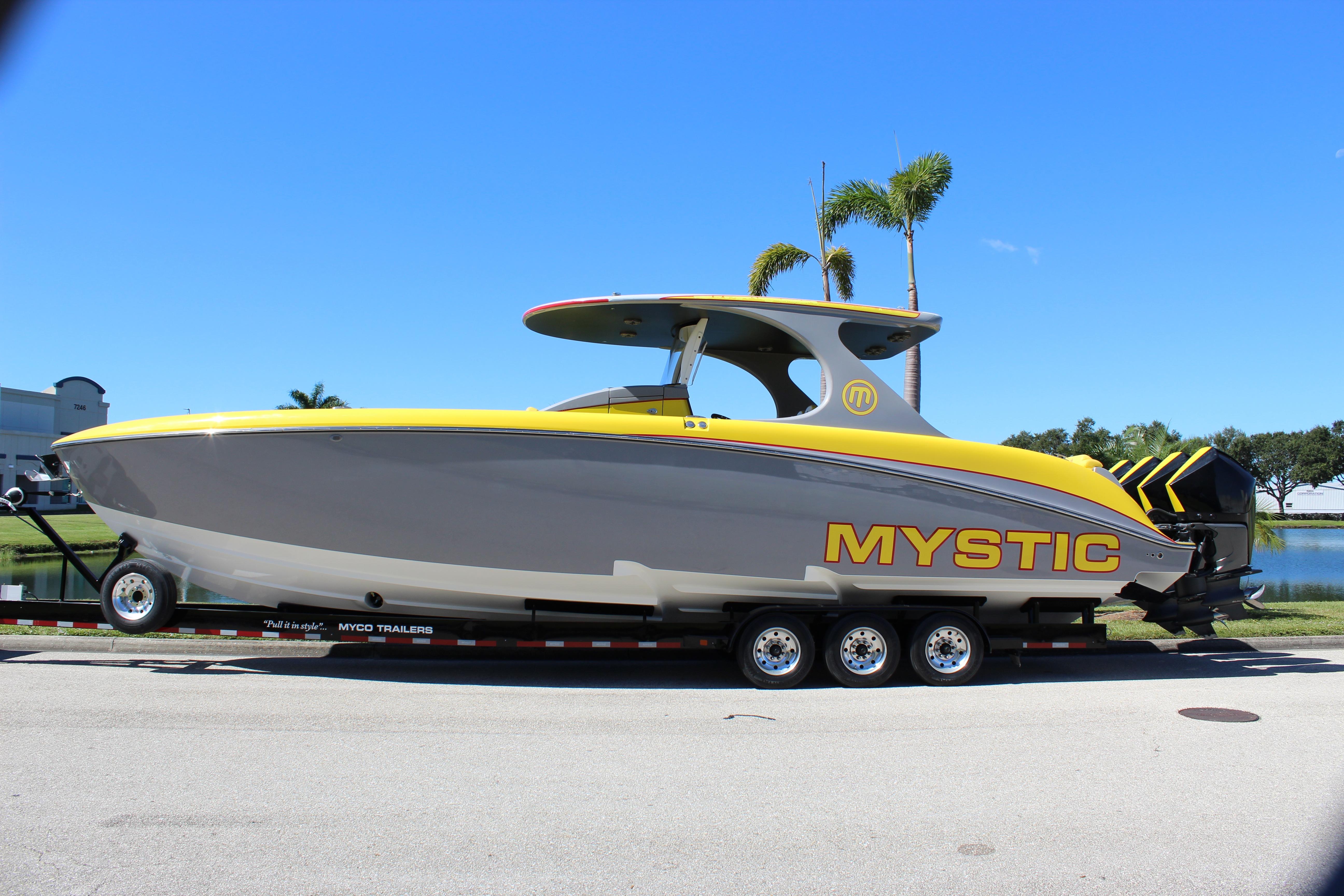 2021 Mystic M4200 powerboat on trailer, featuring sleek yellow and gray design.