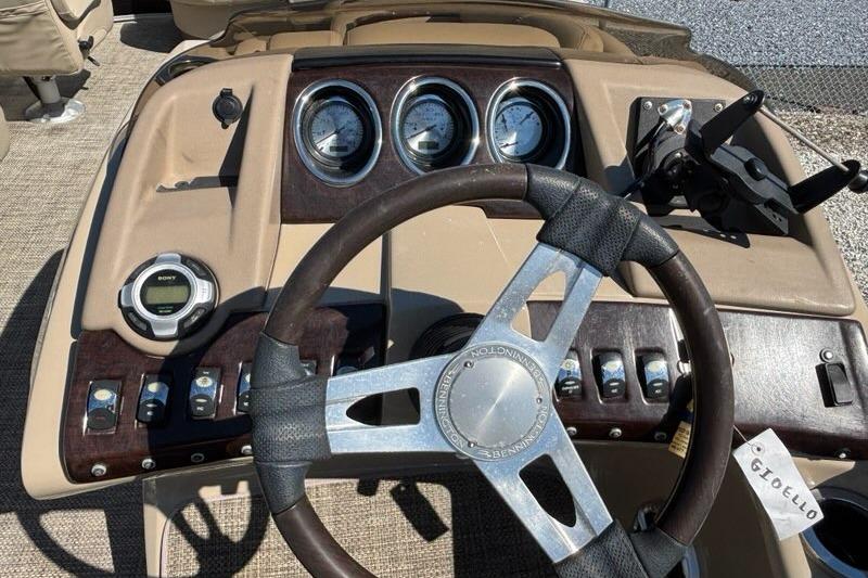 Steering console of a 2014 Bennington 2575 RCW boat with gauges and controls.