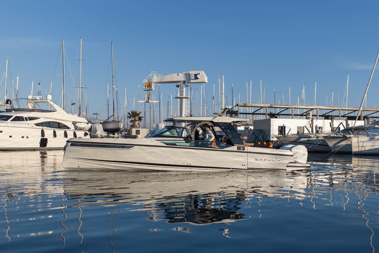 Saxdor SX320 GTO 2027 in a marina with other yachts in the background.