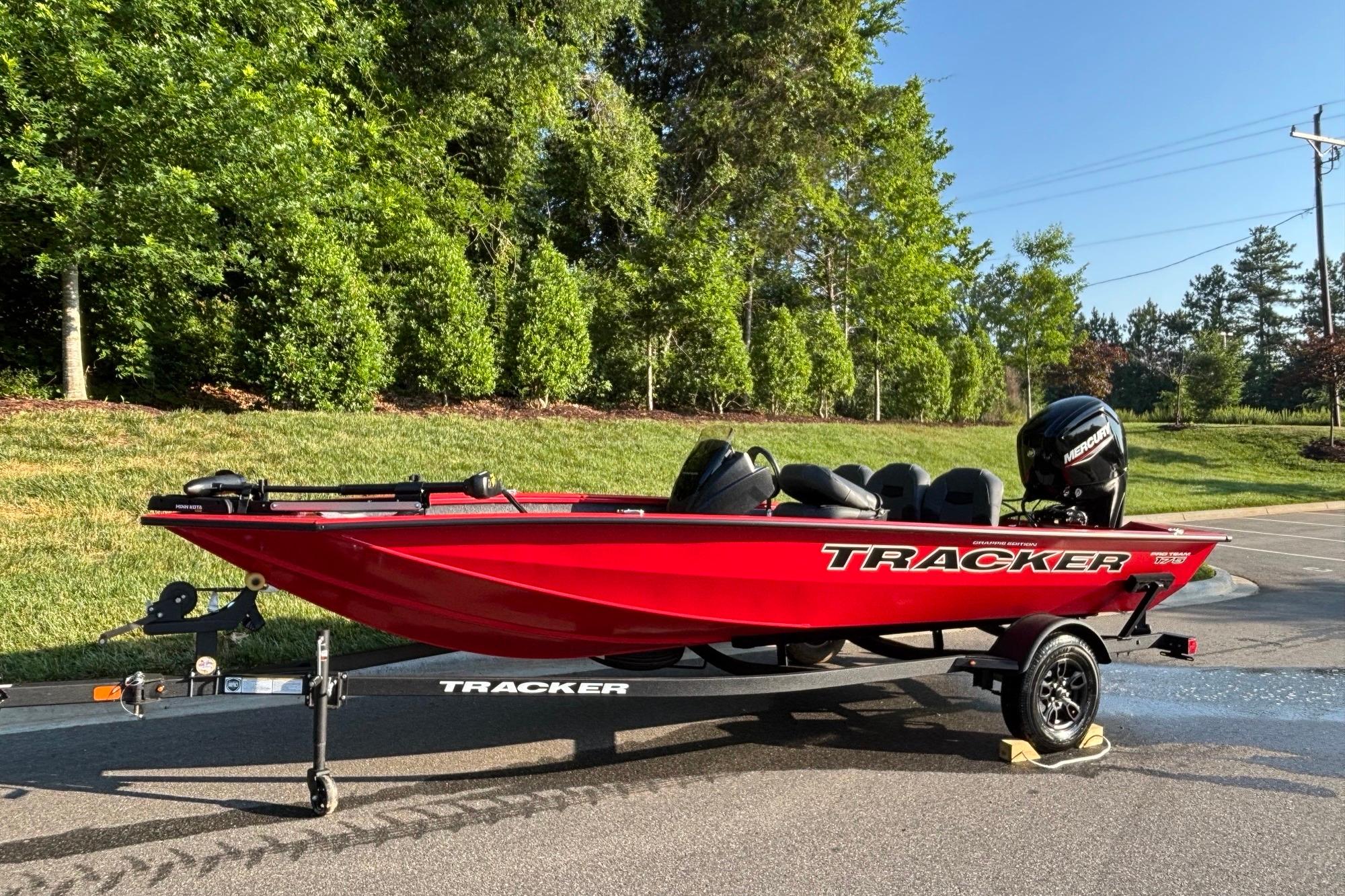 2026 Tracker Pro Team 175 Crappie Edition boat, vibrant red, parked on trailer, sunny day.