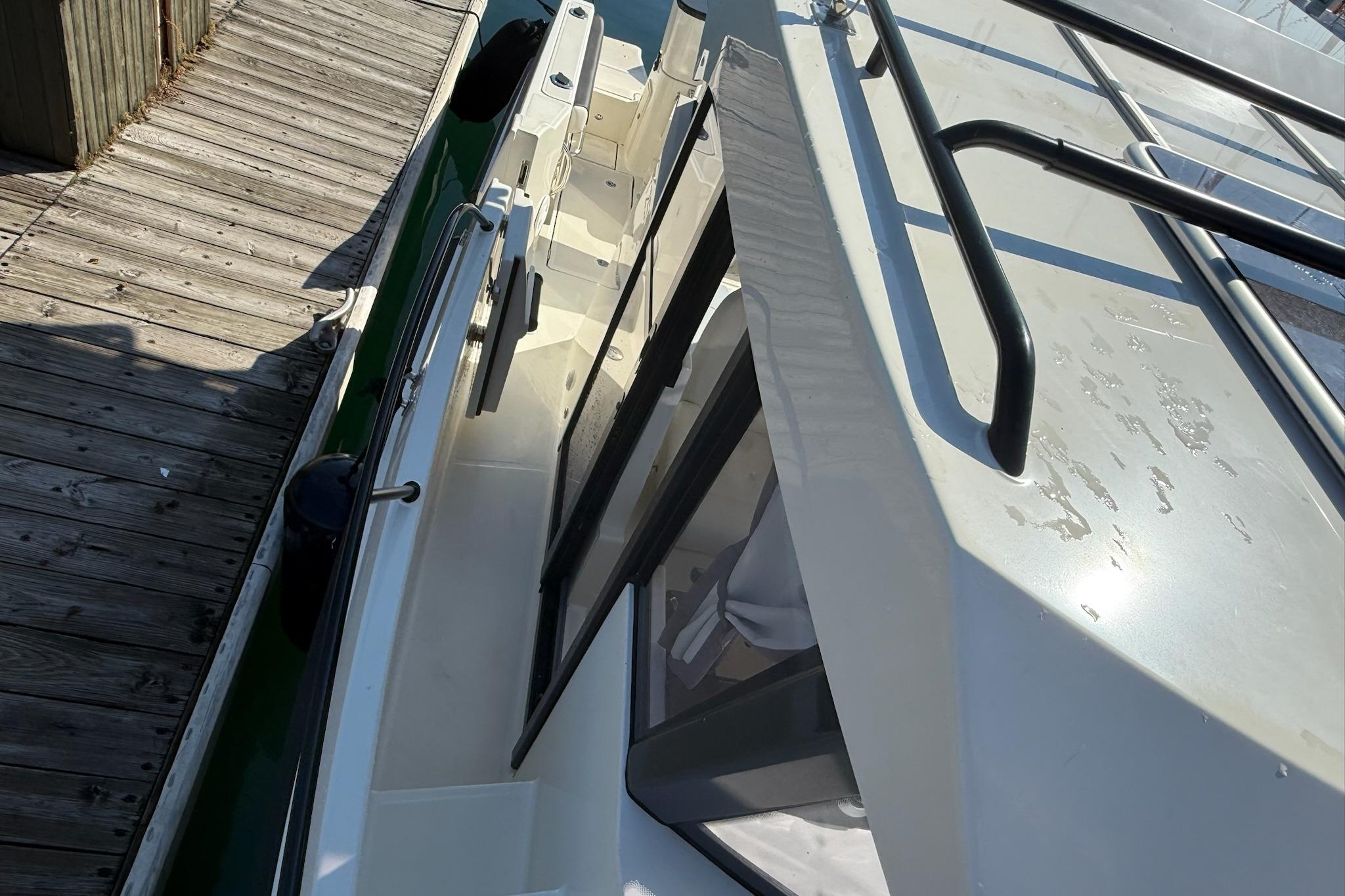 2024 Bayliner Trophy T25 Pilothouse docked, showcasing sleek design and sturdy railings.